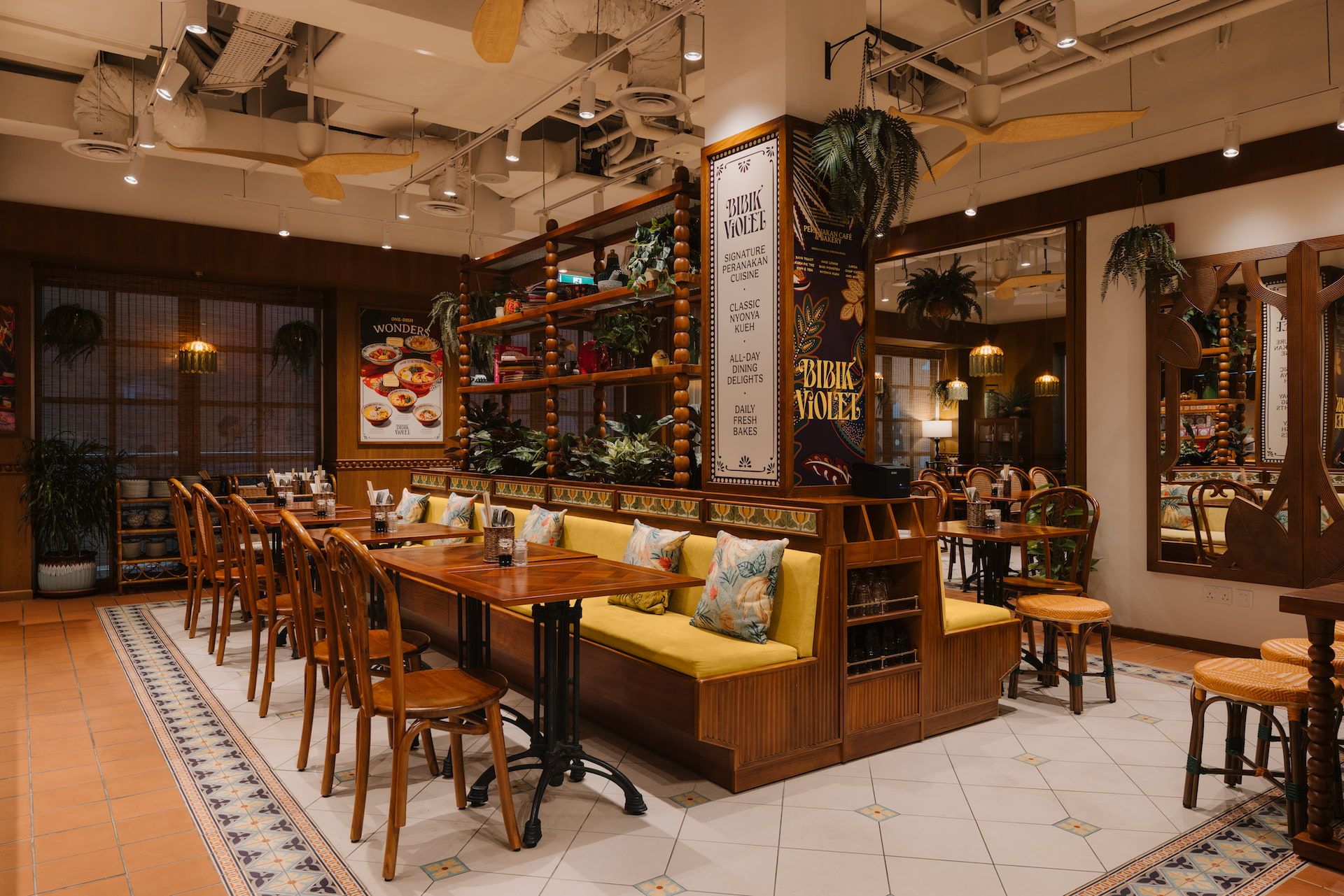 Interior view with rattan pendant lights and yellow banquette seating and bamboo-style joinery, Bibik Violet Singapore by LAANK