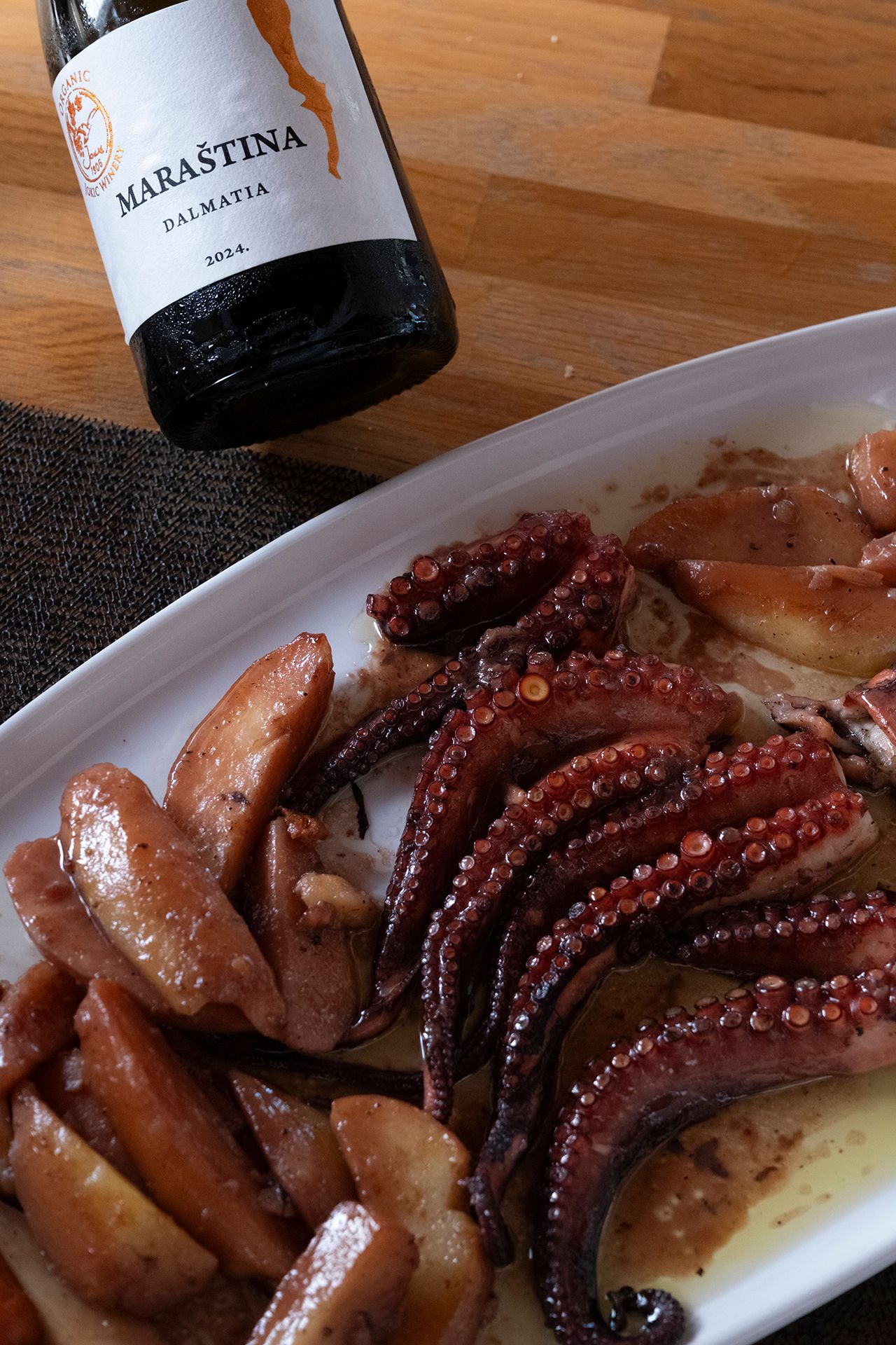 Tanjur hobotnice s krumpirom pod pekom uz bocu organske Maraštine vinarije Jokić.