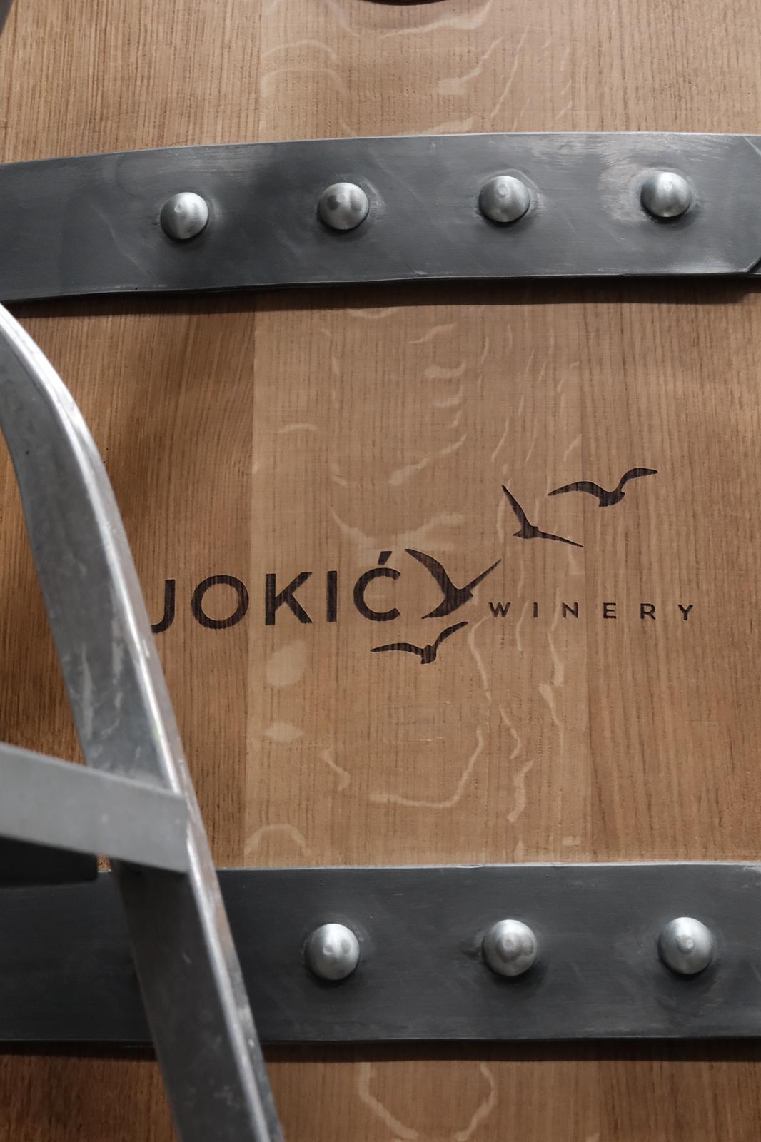 Detalj hrastove bačve sa utisnutim logotipom vinarije Jokić i motivom ptica.