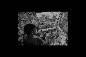 demolished core viewed inside crane cabin with person operating it