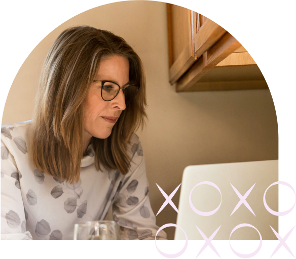 Image-10.png Woman wearing glasses working on a laptop at home, with decorative X and O elements in the corner.