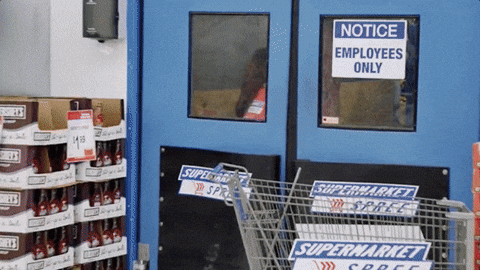 wholesale+melissa+mccarthy+GIF+by+Saturday+Night+Live.gif A woman in an orange uniform hugs a large rolled mattress near a store door marked 'Employees Only.'