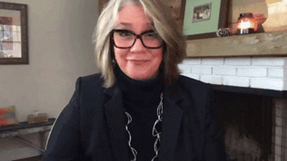 93477a97-d7bd-76da-144f-db6195b23b1b.gif A woman in glasses holds two green pea toys near her face as on-screen text spells out 'Pretty peas!'