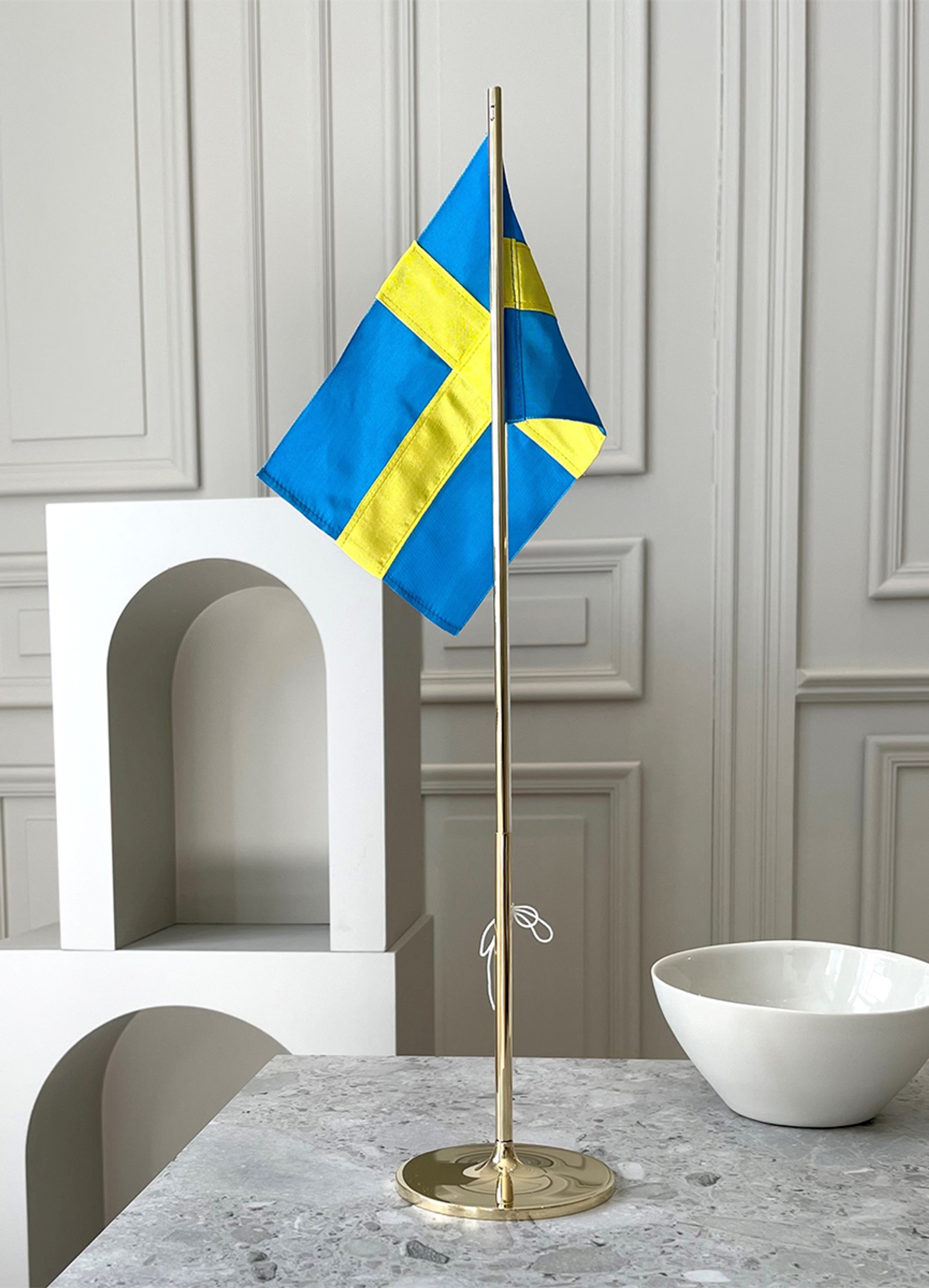 Bordsflagga med den svenska flaggan på marmorbänk
