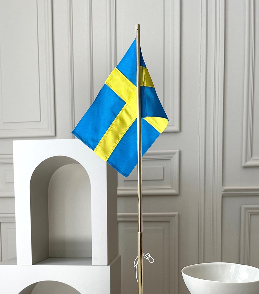 Bordsflagga med den svenska flaggan på marmorbänk