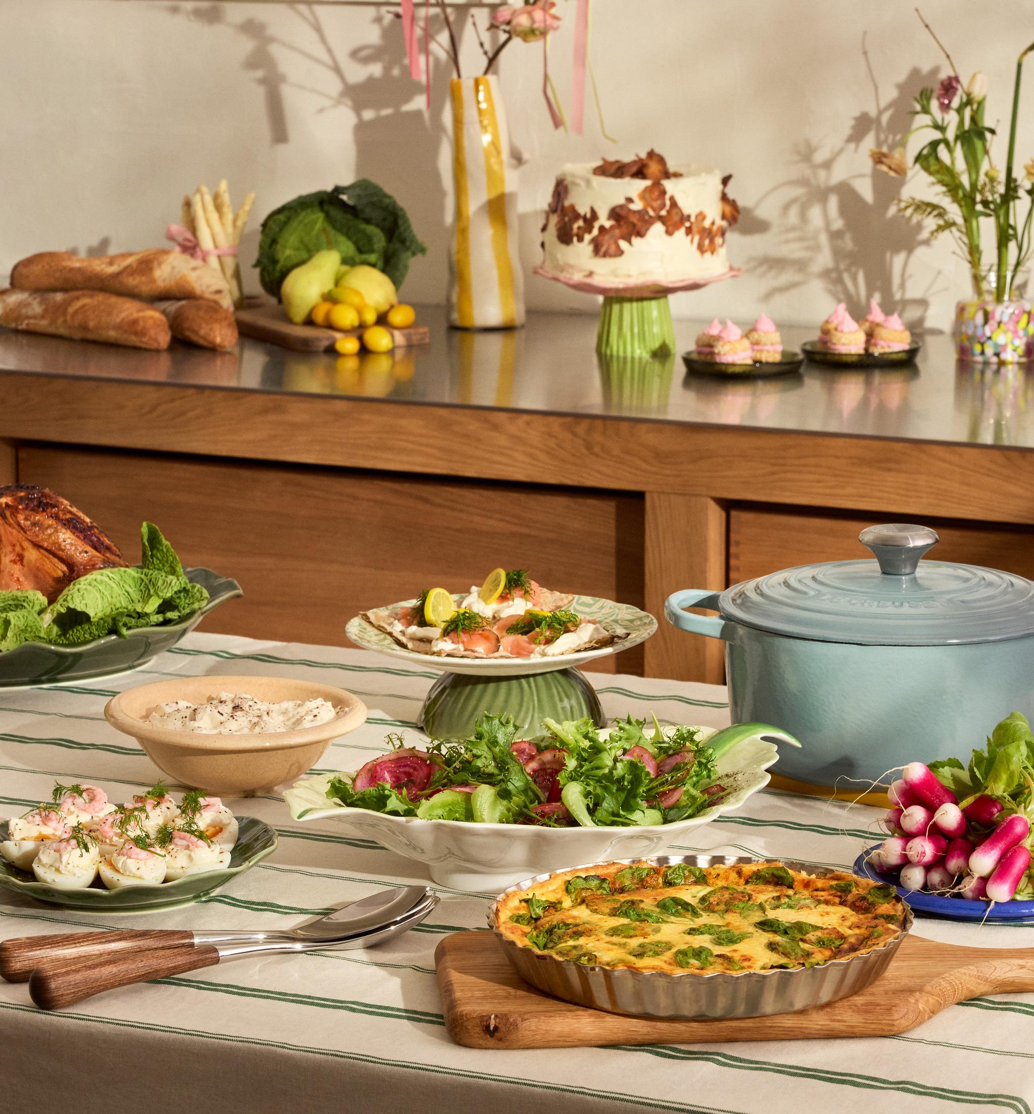 Uppdukad påskbuffé på ett bord - ägghalvor, paj och gravad lax