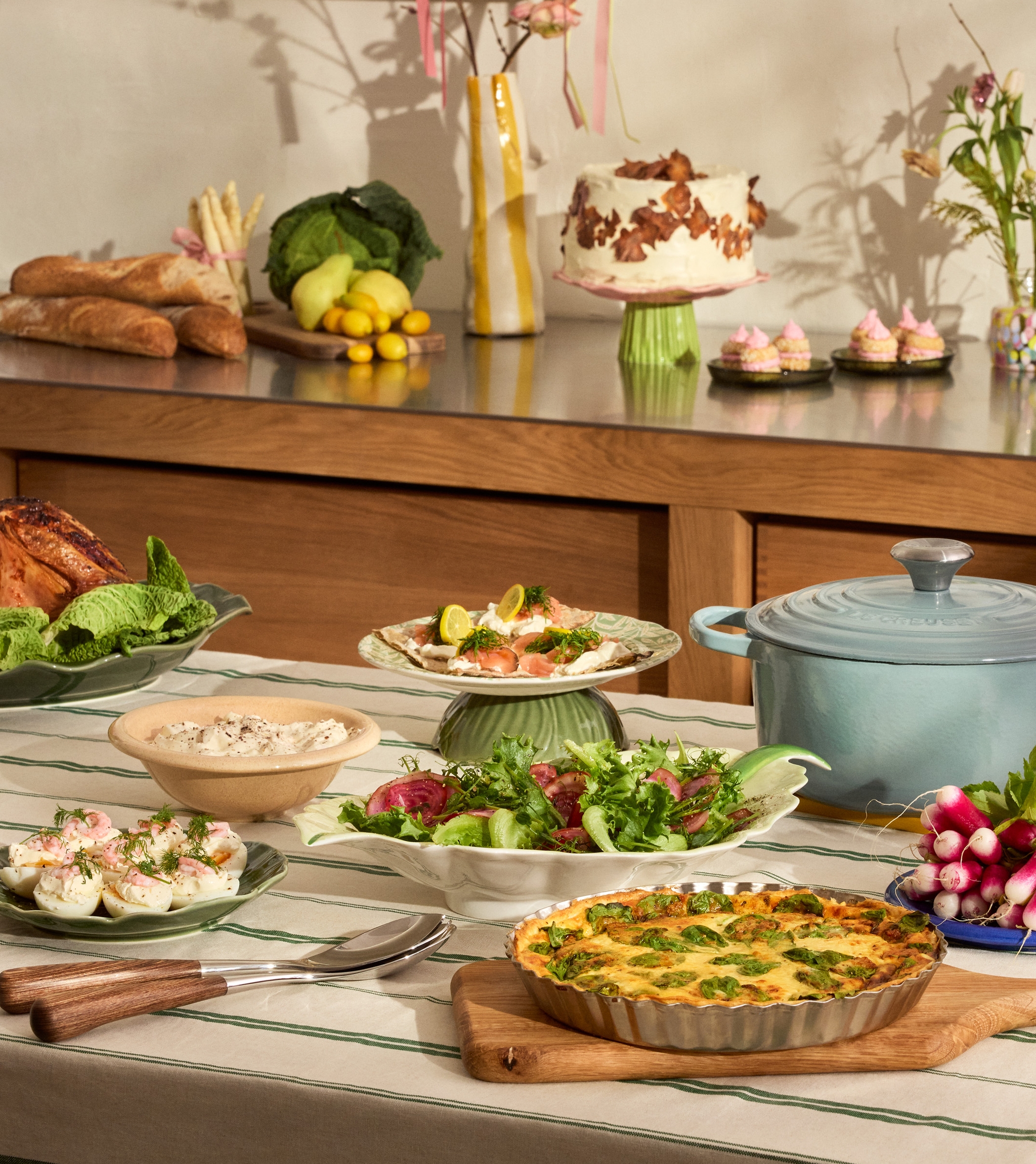 Uppdukad påskbuffé på ett bord - ägghalvor, paj och gravad lax