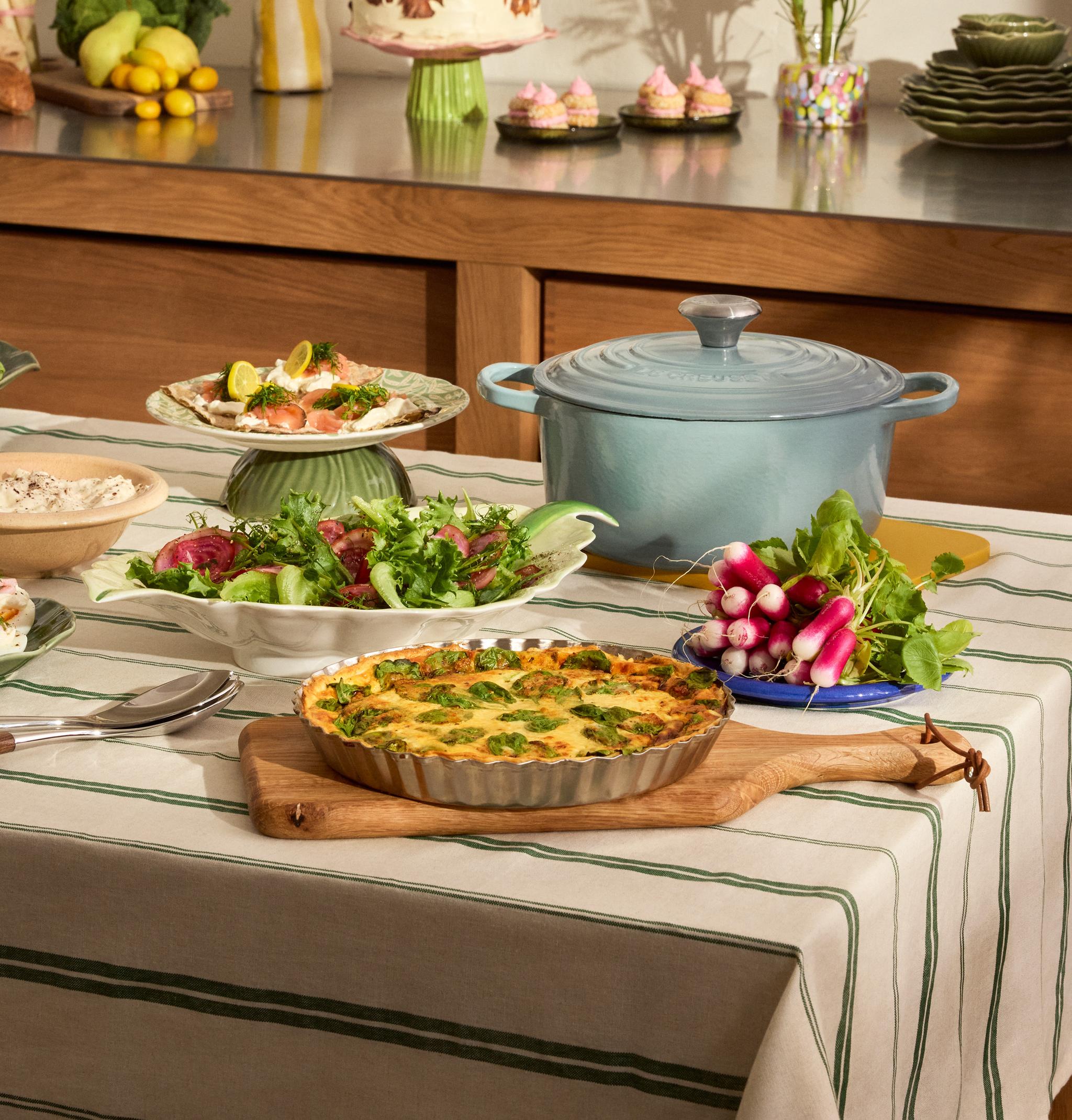 Uppdukad påskbuffé på ett bord - ägghalvor, paj och gravad lax