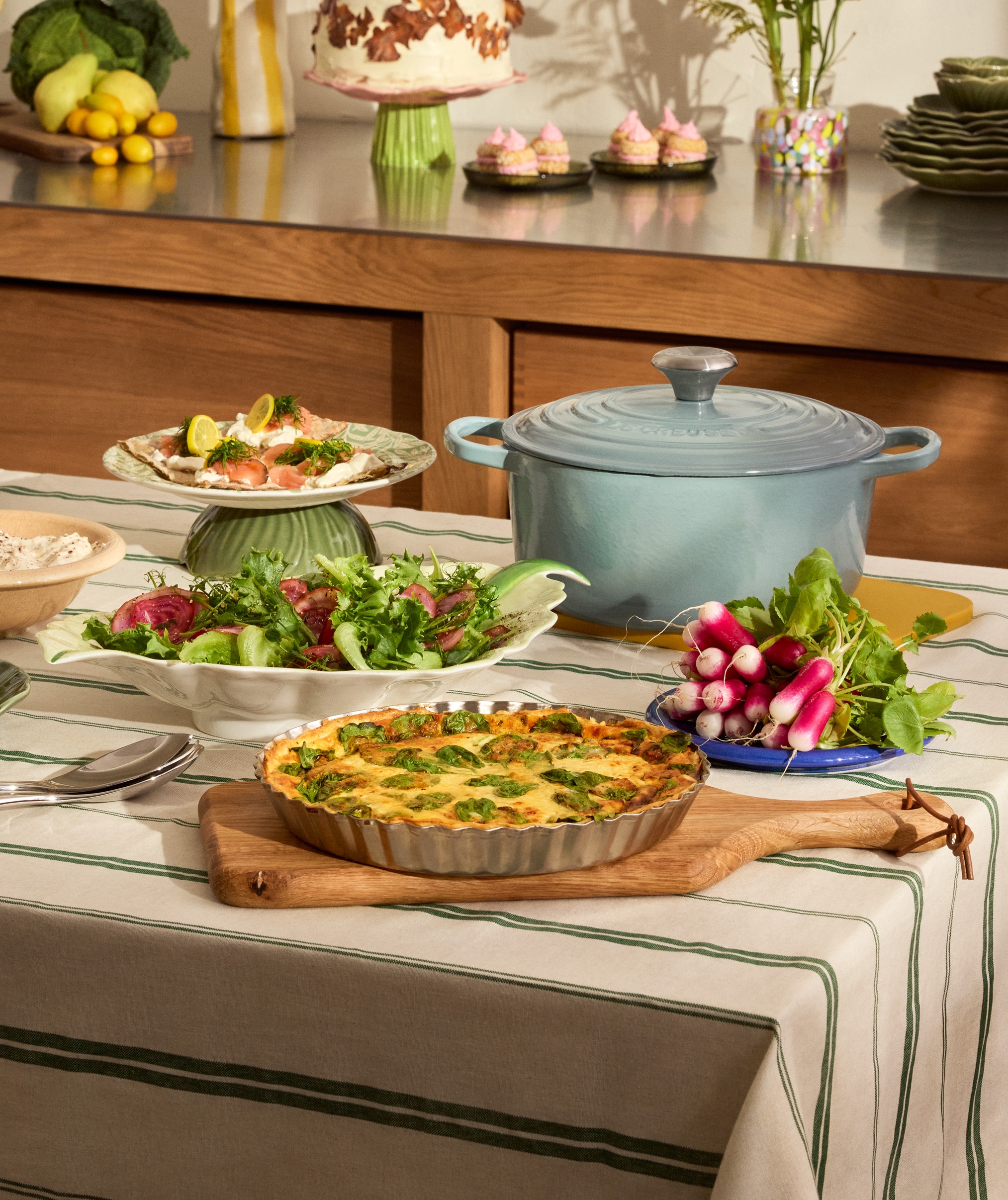 Uppdukad påskbuffé på ett bord - ägghalvor, paj och gravad lax