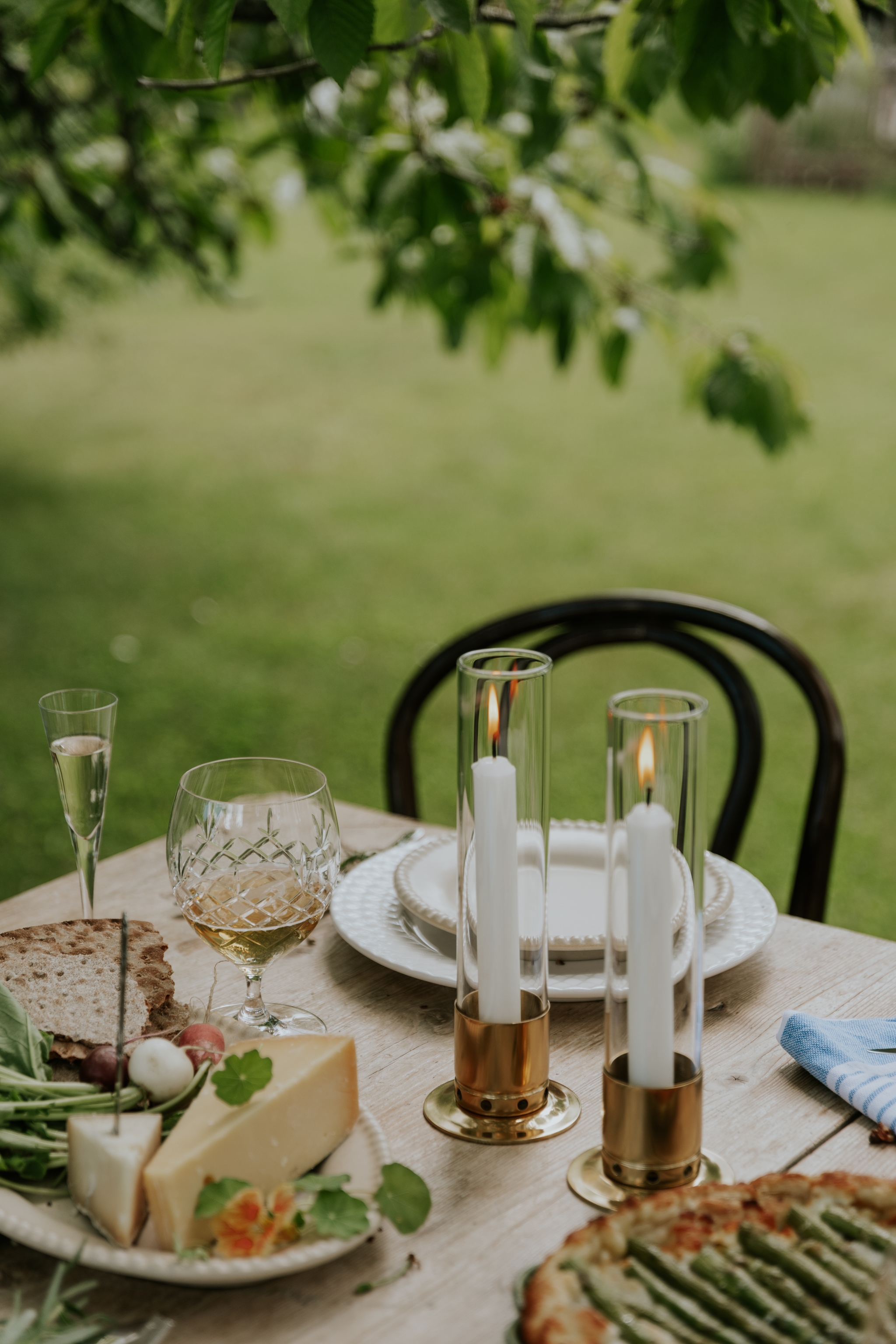 Pöydän kattaus rapujuhliin juustotarjotin tarjoilulautanen kynttilälyhdyt kynttilät juustopiirakka viinilasit snapsilasit