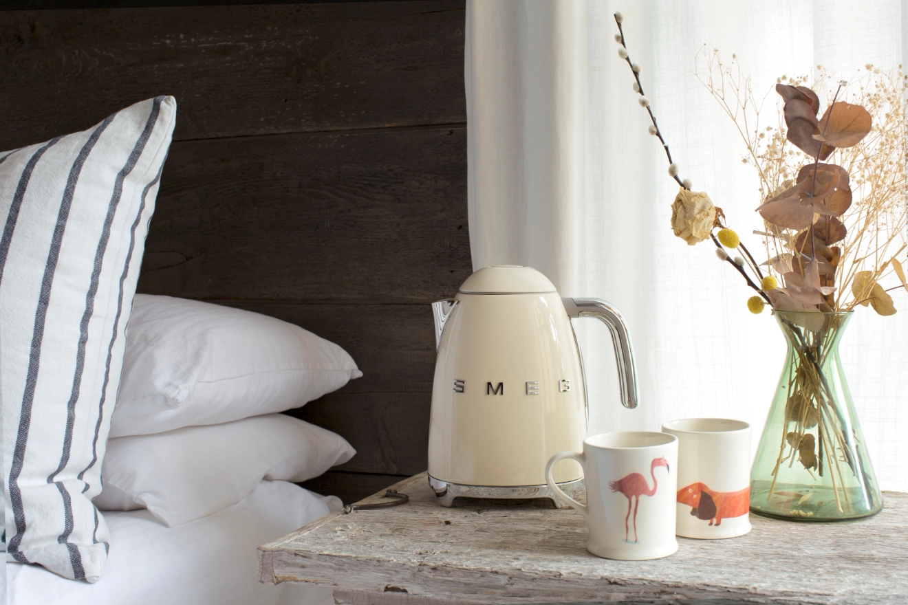 Smeg vattenkokare i creme på ett nattduksbord i somrumet
