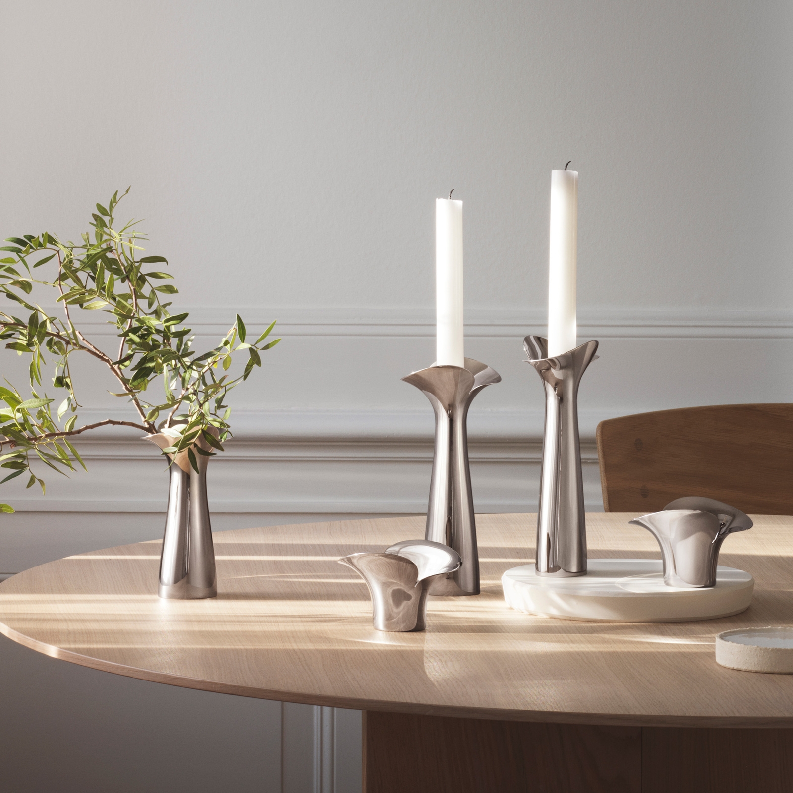 Georg Jensen ljusstake i blankpolerat silver på ljust träbord