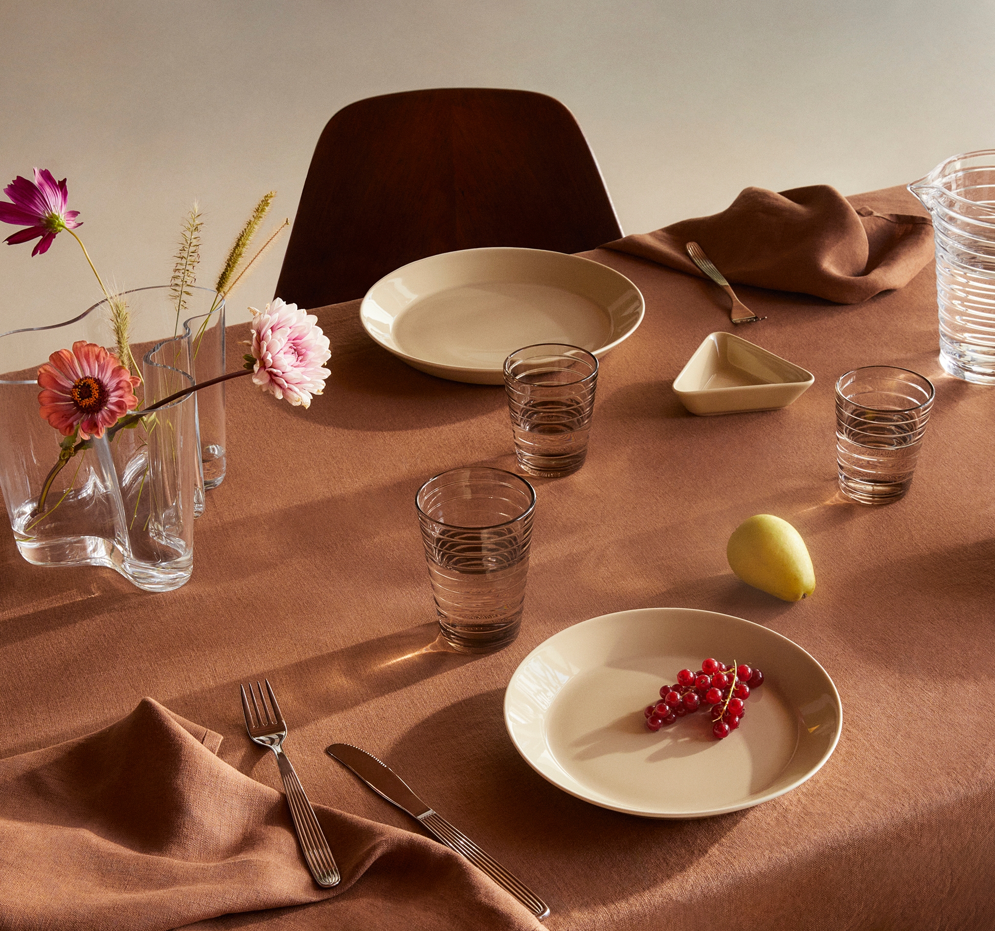 Teema lautaset ja Iittala vesilasit katetulla pöydällä