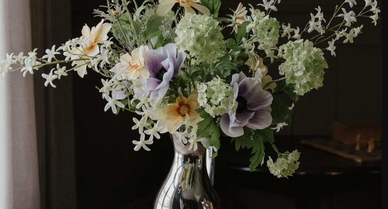 mr plant blombukett av konstgjorda blommor i en blank rostfri vas