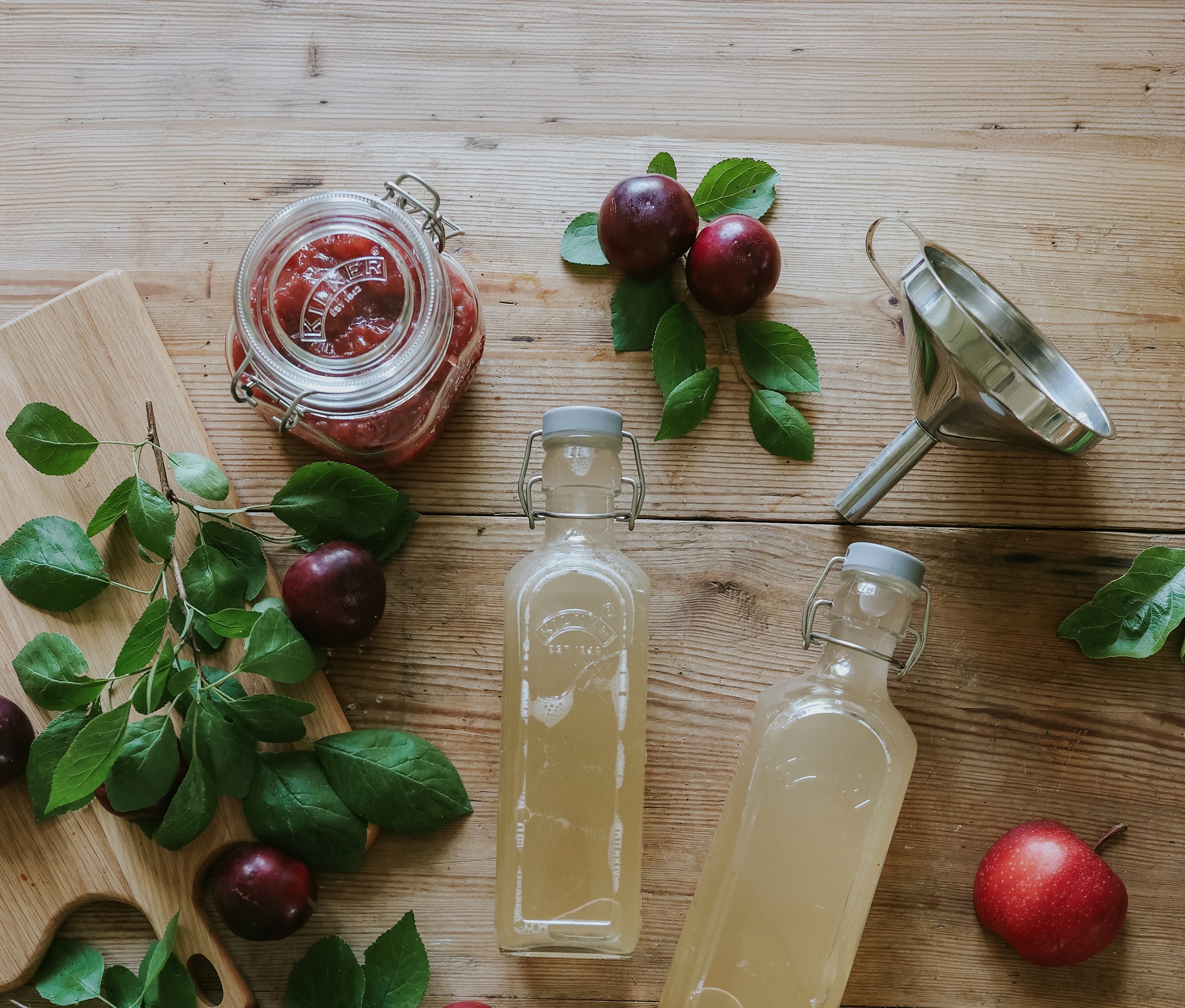 Hjemmelaget syltetøy og saft i glass og flasker på et trebord