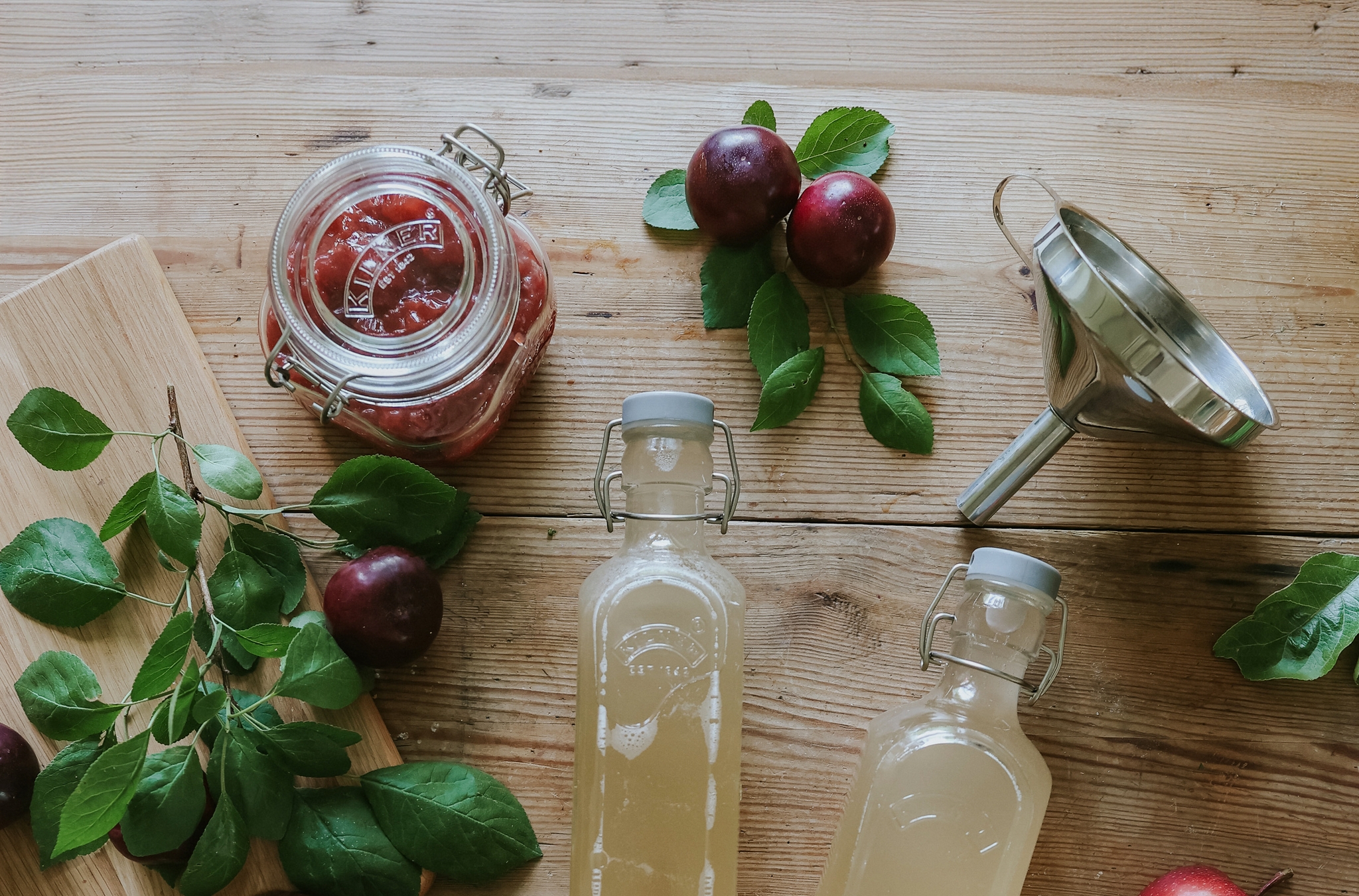 Hjemmelaget syltetøy og saft i glass og flasker på et trebord