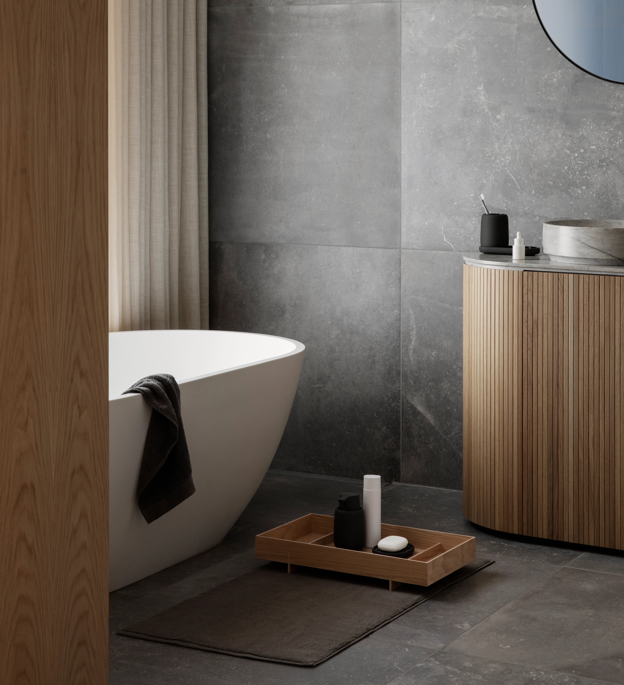 Vitt badkar i ett kaklat badrum i sten med trädetaljer