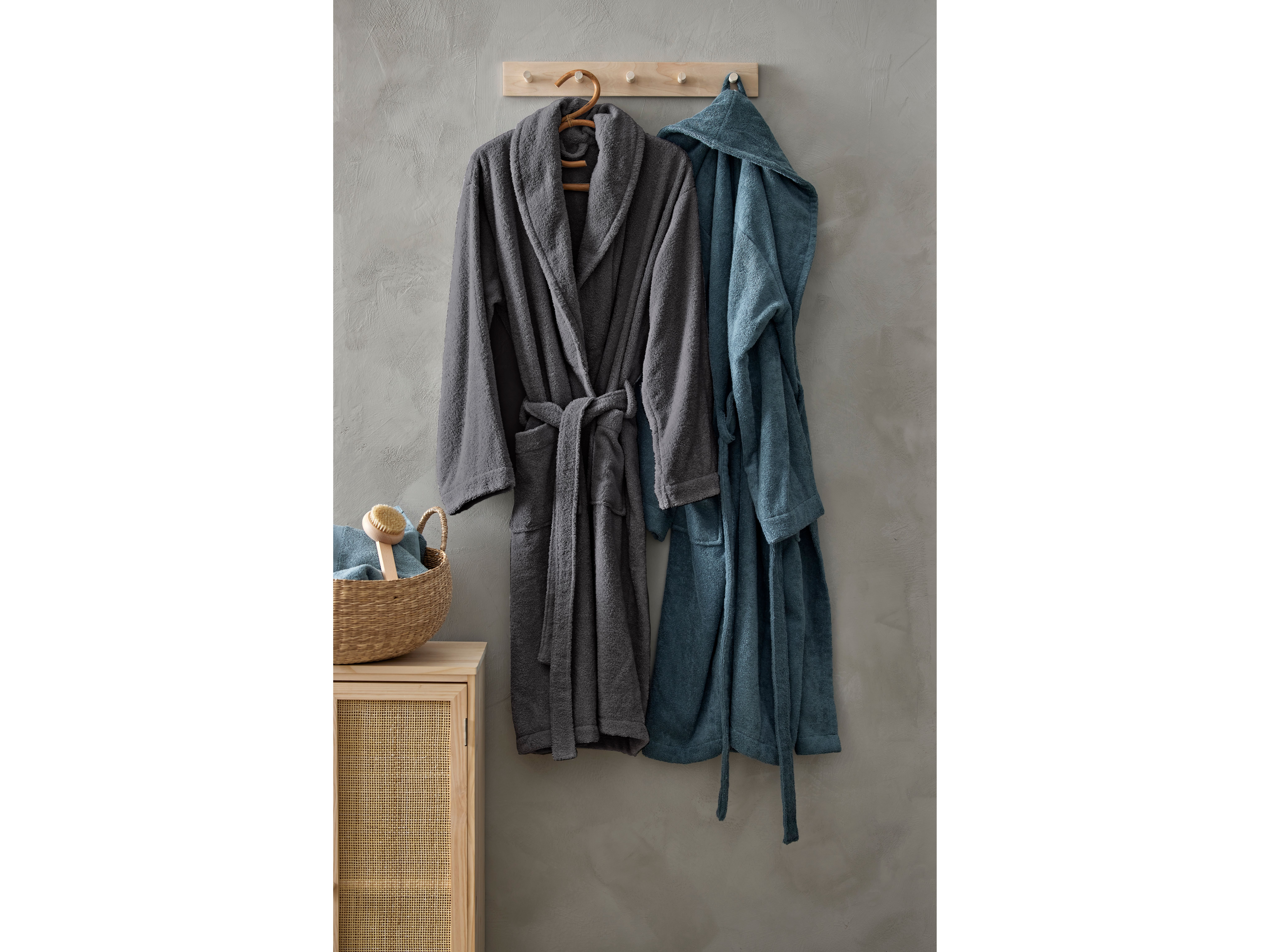To morgenkåper henger på en kroklist i tre på et bad