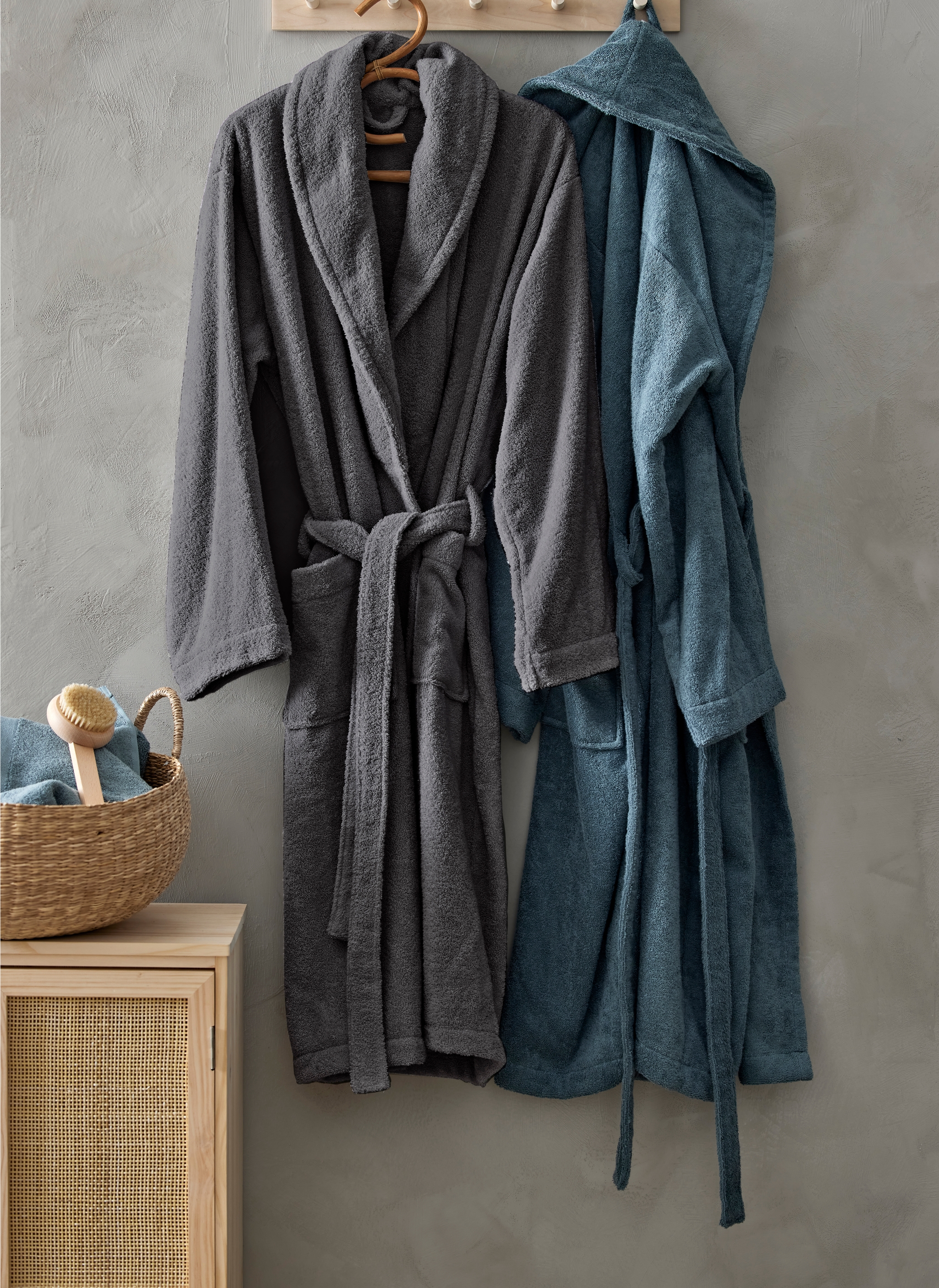 To morgenkåper henger på en kroklist i tre på et bad