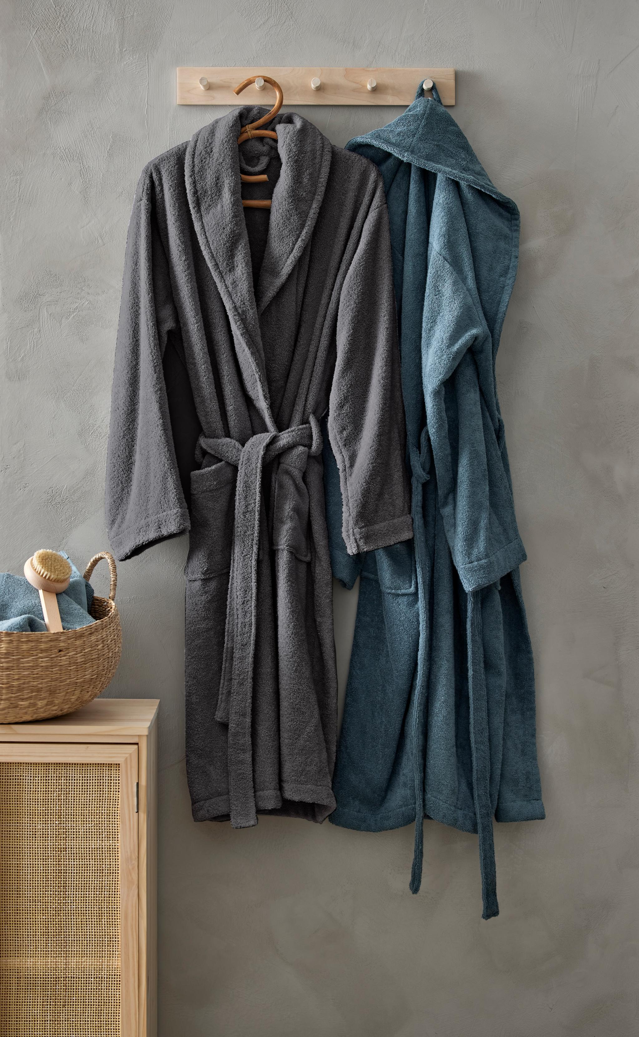 To morgenkåper henger på en kroklist i tre på et bad