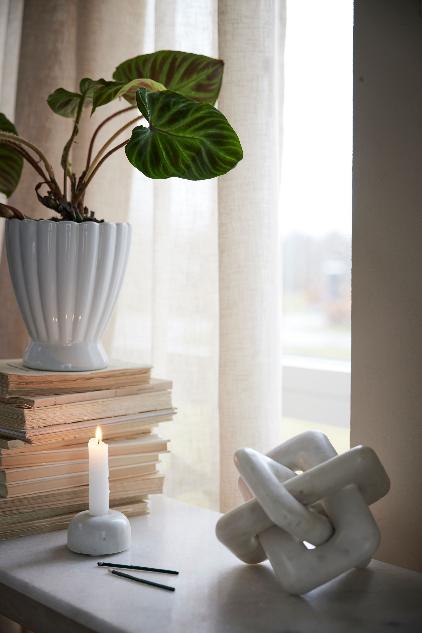 Marmori koriste ja marmori kynttilänjalka ikkunalaudalla