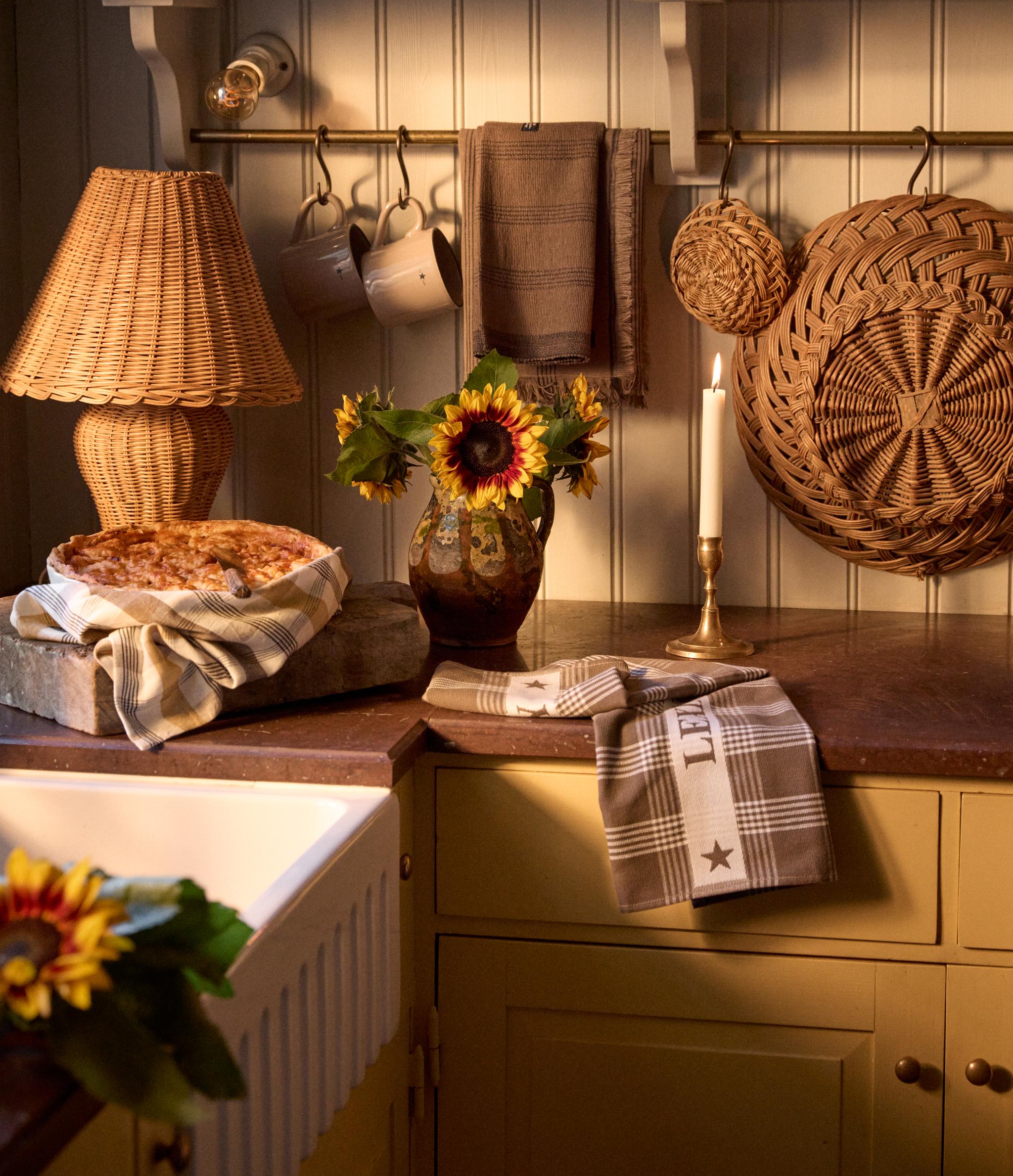 en köksbänk med en paj och en rottinglampa