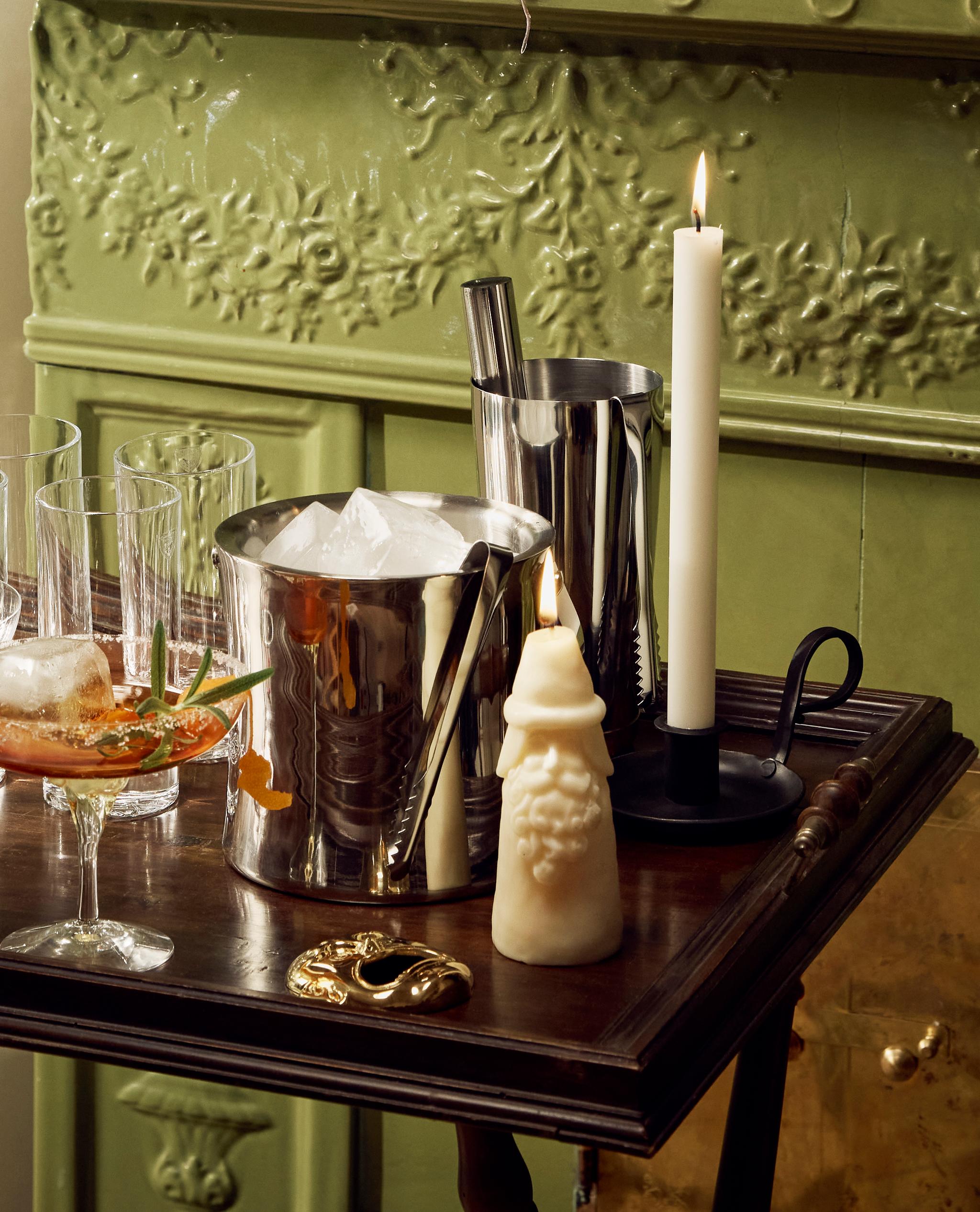 pöytä, jossa on cocktaillasit, jääämpäri ja ravistin