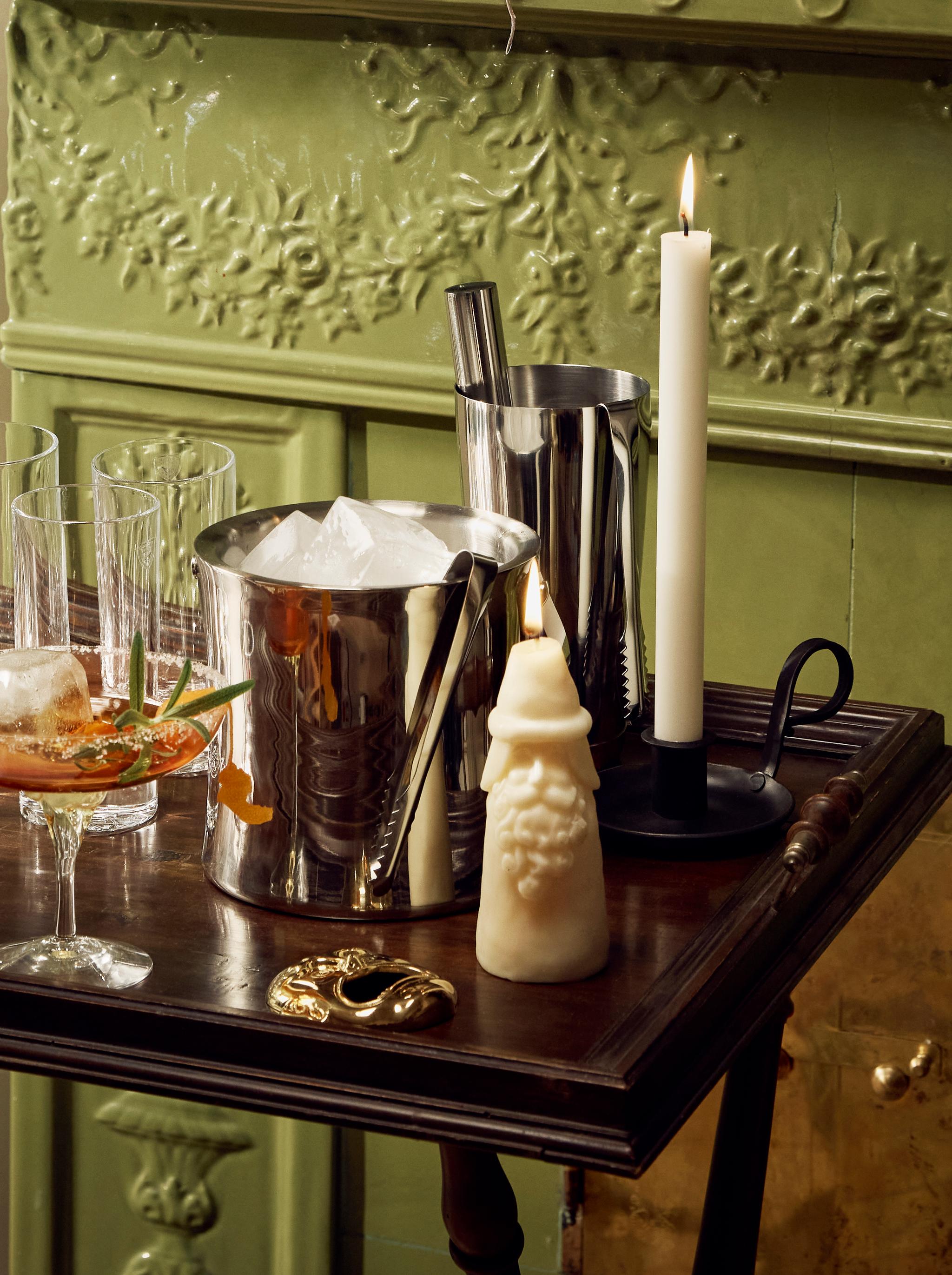 Glas, en ishink och en shaker står på en drinkvagn