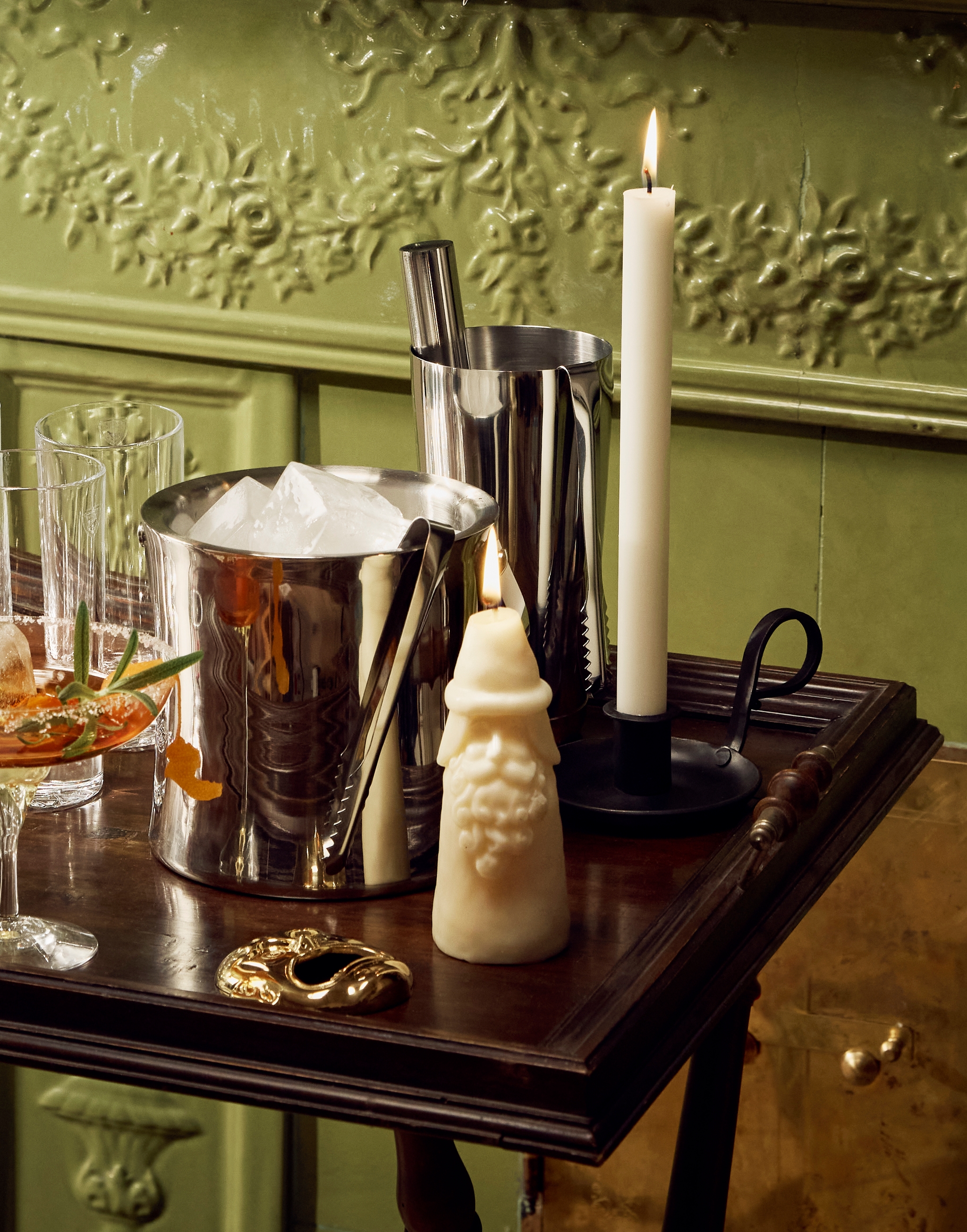 Glas, en ishink och en shaker står på en drinkvagn