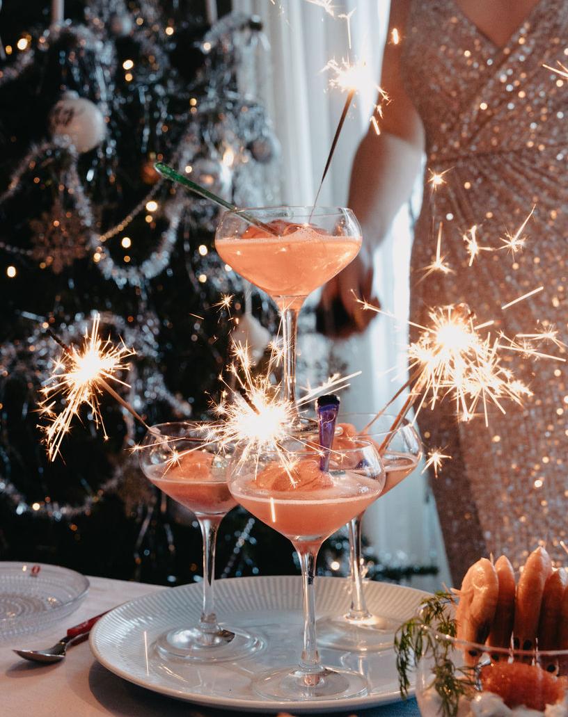 Champagneglass med tente stjerneskudd i