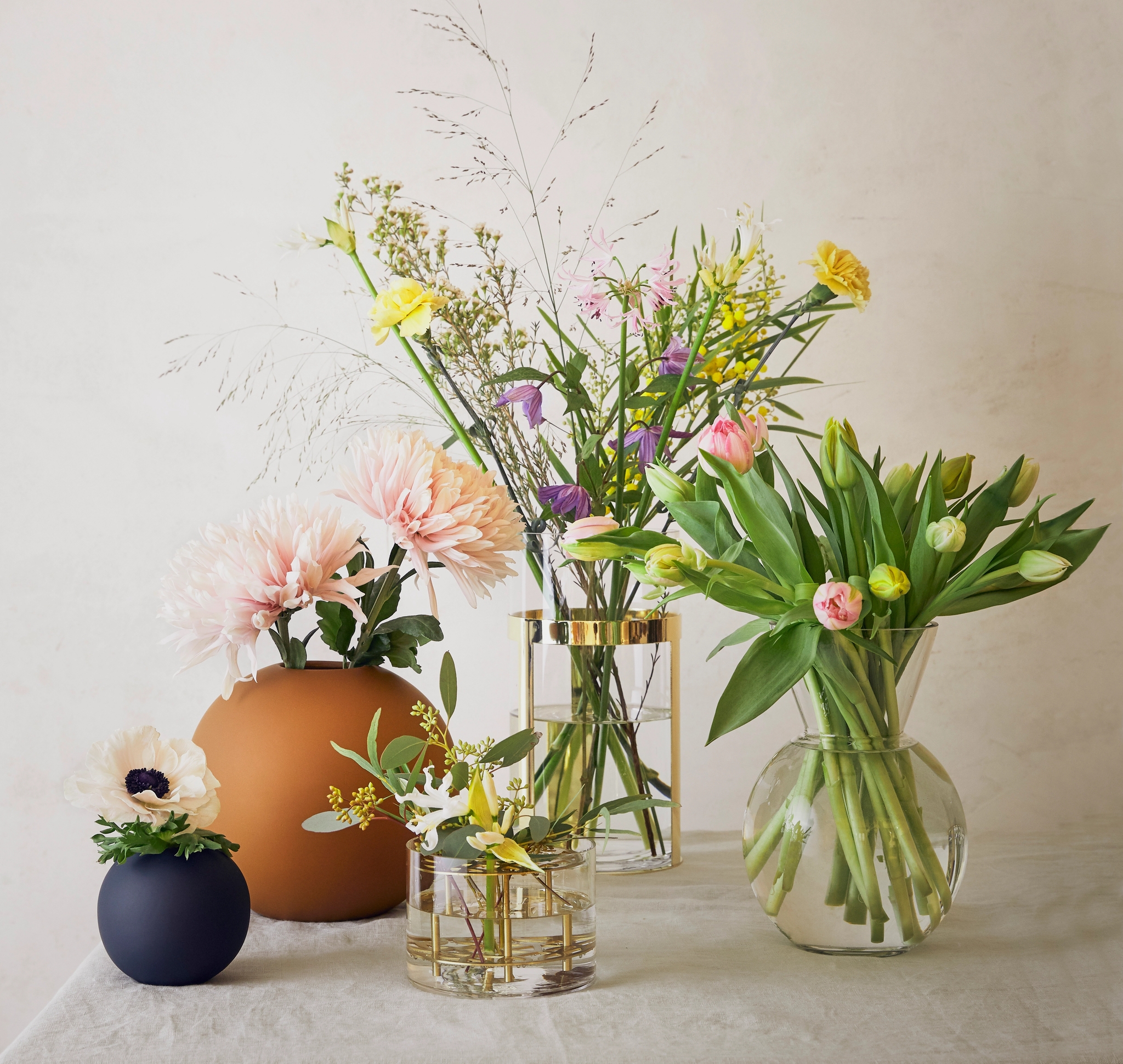 Pyöreät cooee maljakot ja sylinterin muotoiset lasimaljakot kultaisilla yksityiskohdilla kukkakimppujen kera