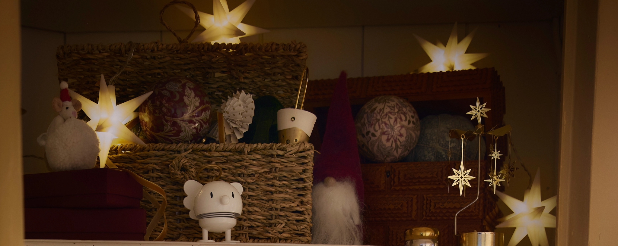 Et skap fylt med juledekorasjoner og en skål med julekuler