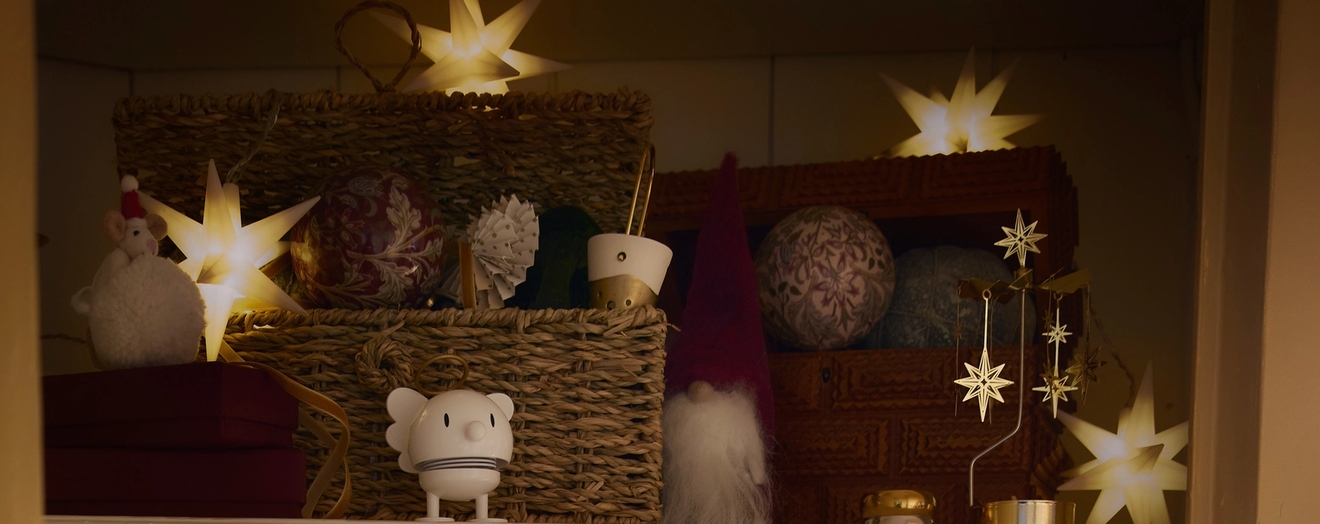 ett skåp fyllt med juldekorationer och en skål med julgranskulor