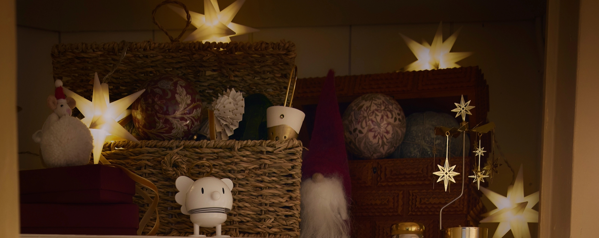 ett skåp fyllt med juldekorationer och en skål med julgranskulor