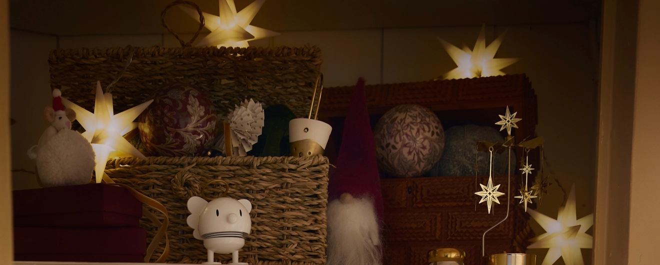 Kotoisa kaappi, joka on koristeltu joulua varten tähtivaloilla, koristeilla, lahjoilla ja hohtavilla valosarjoilla.