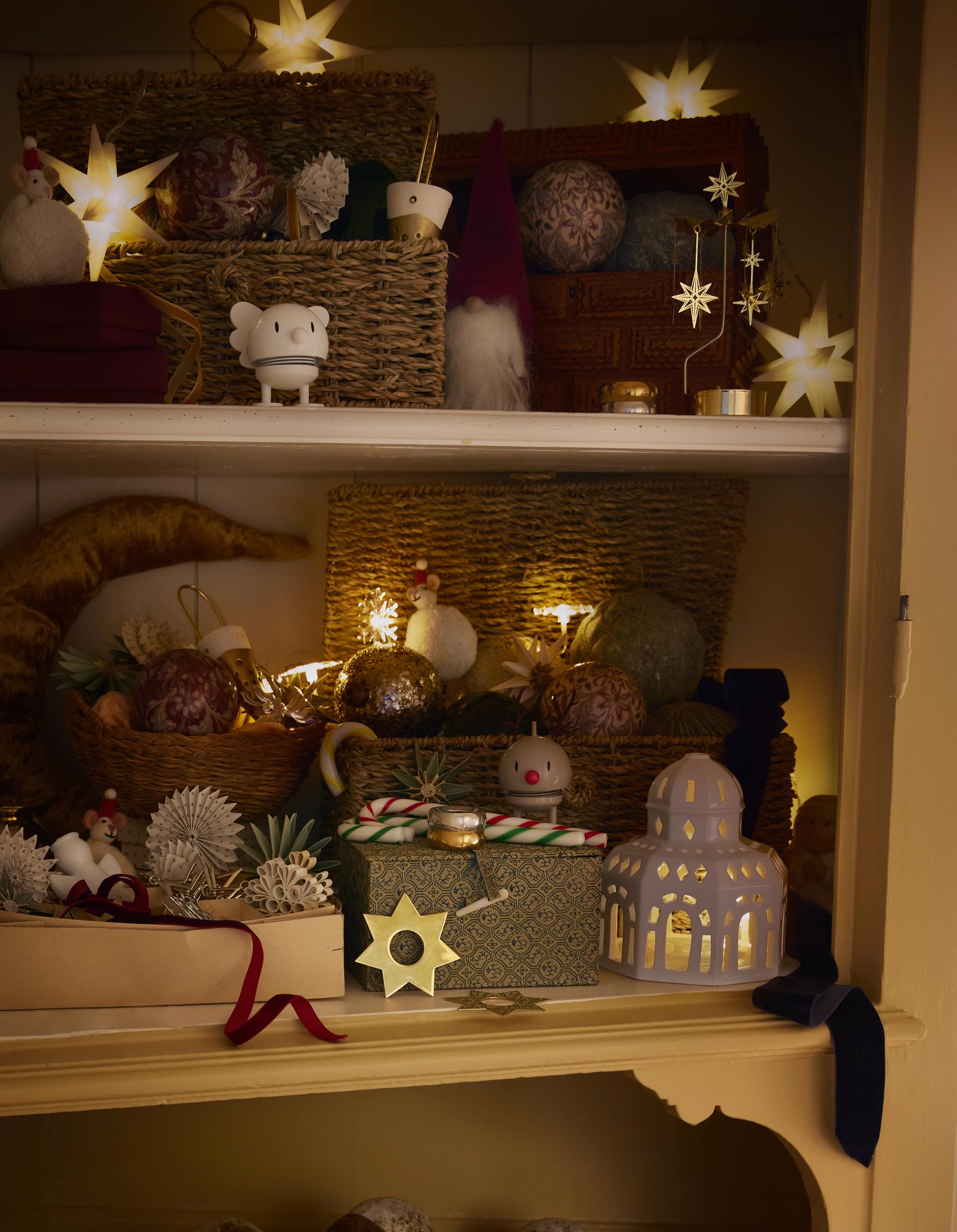 ett skåp fyllt med juldekorationer och en skål med julgranskulor