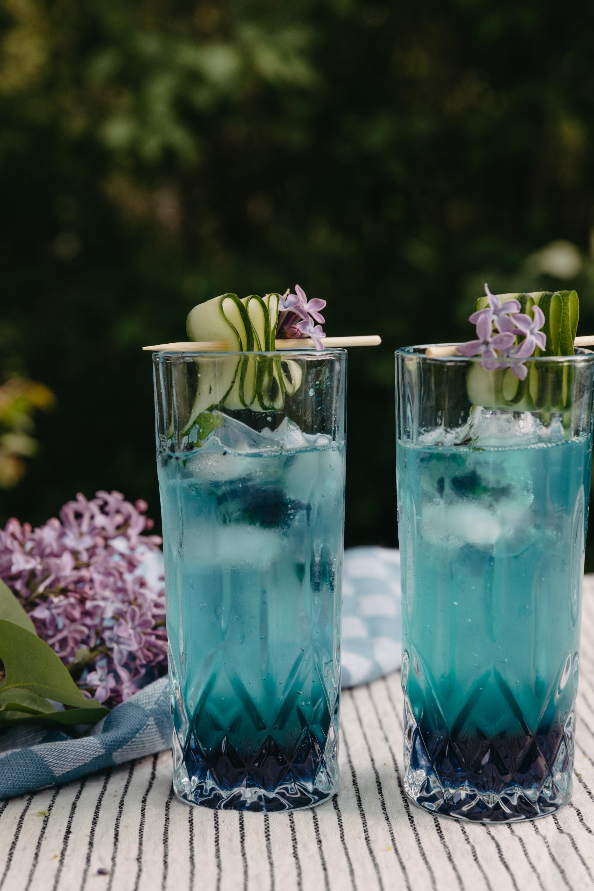 Sininen drinkki sininen cocktail mocktail koristeltu vihanneksilla ja syötävät kukat