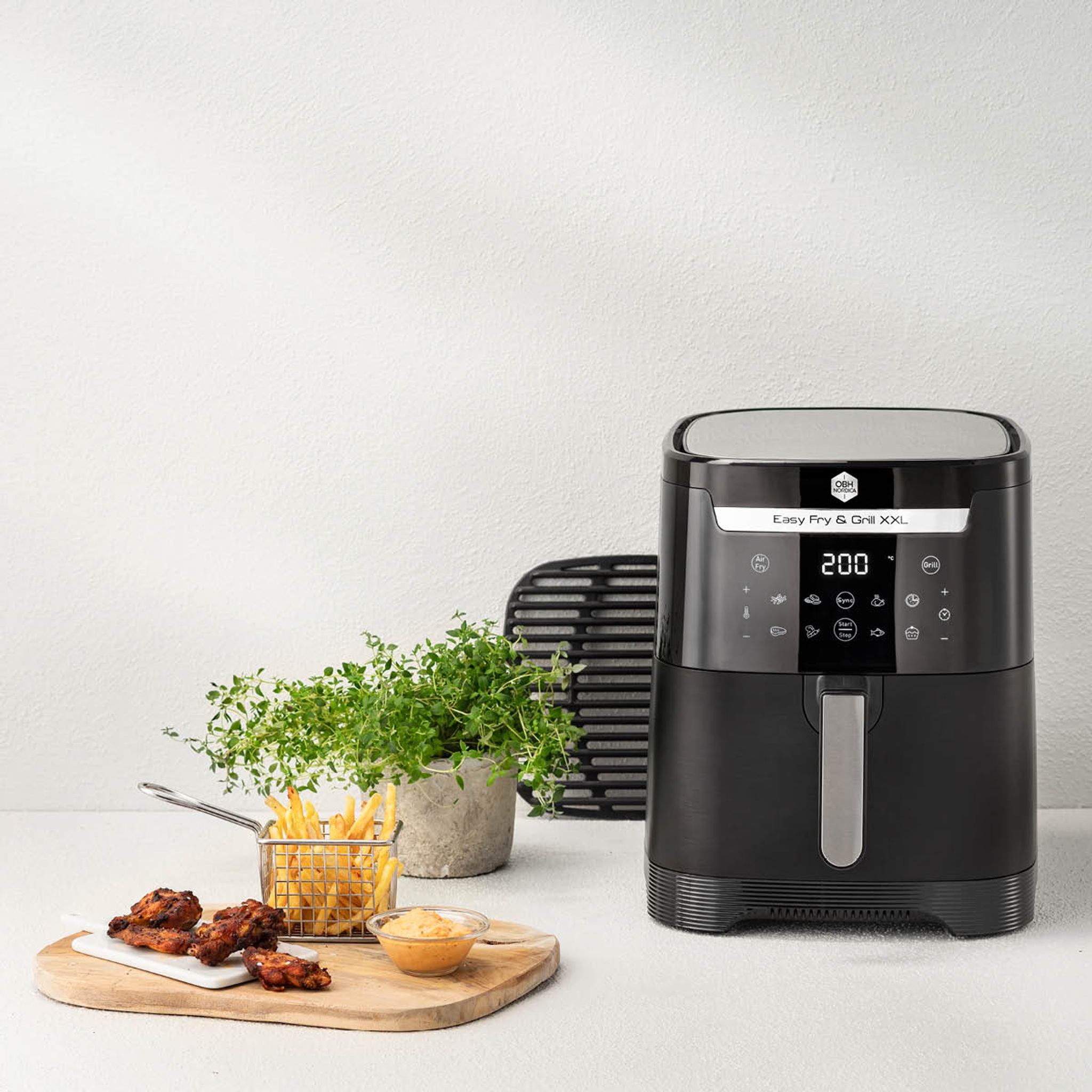 OBH Nordica airfryer, friteeratut kanankoivet ja ranskalaiset perunat pöydällä. 