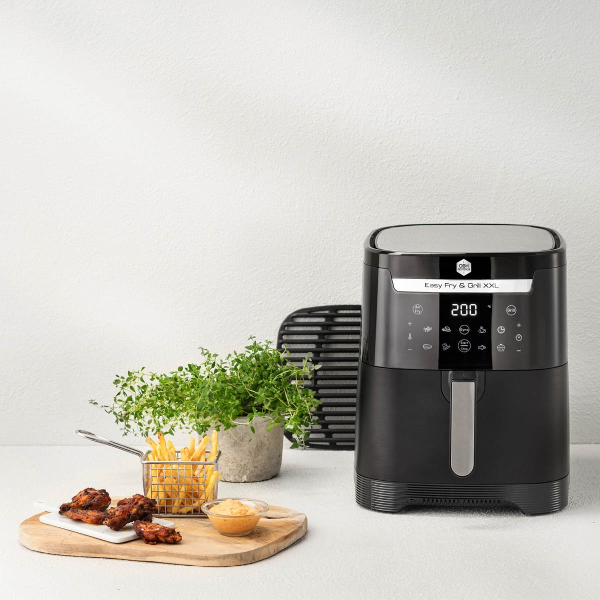 OBH Nordica airfryer, friteeratut kanankoivet ja ranskalaiset perunat pöydällä.