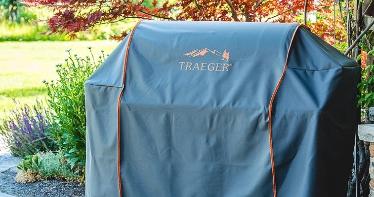 Grillöverdrag Traeger på grill ståendes i trädgård 