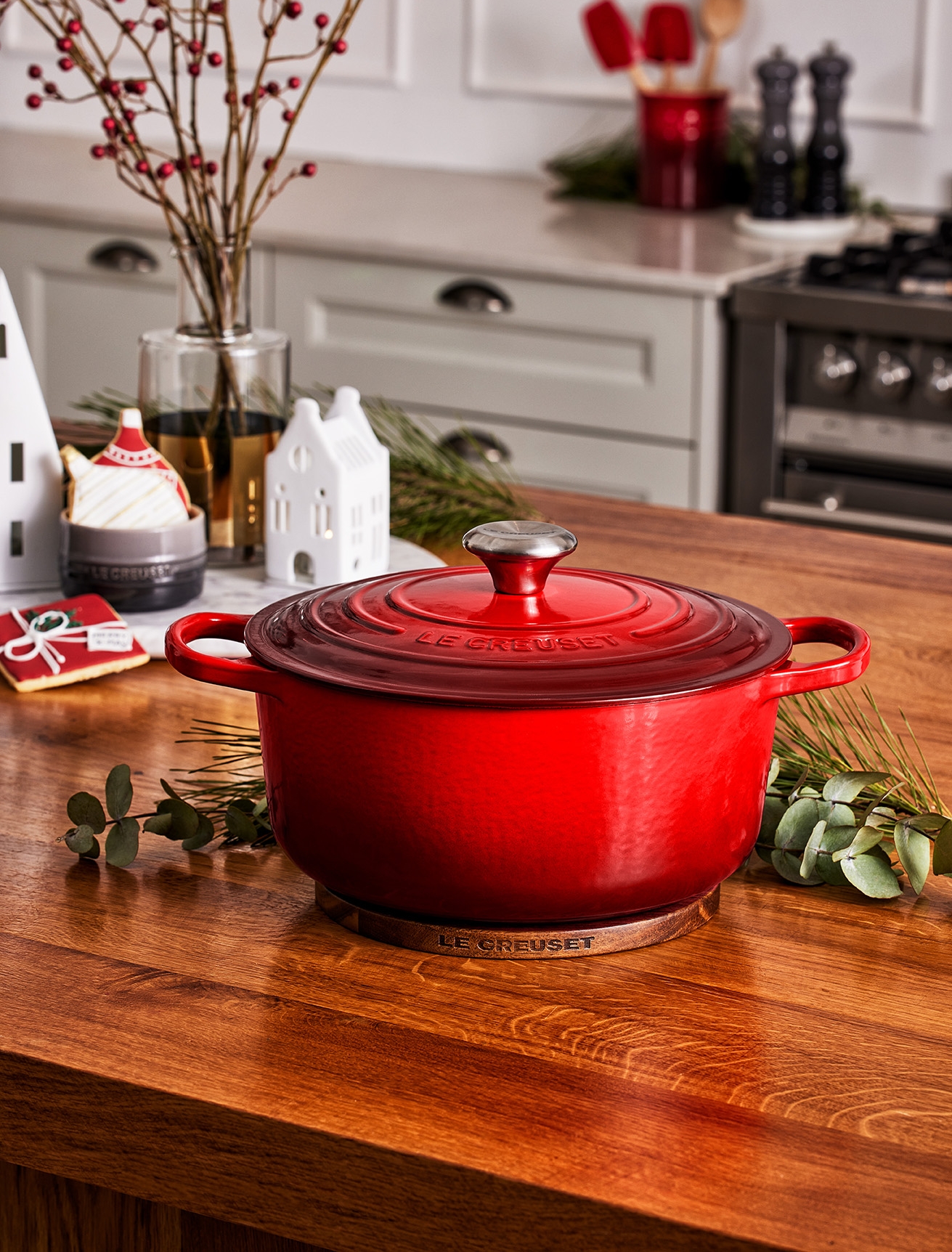 En röd Le Creuset-gryta står på en träbänk