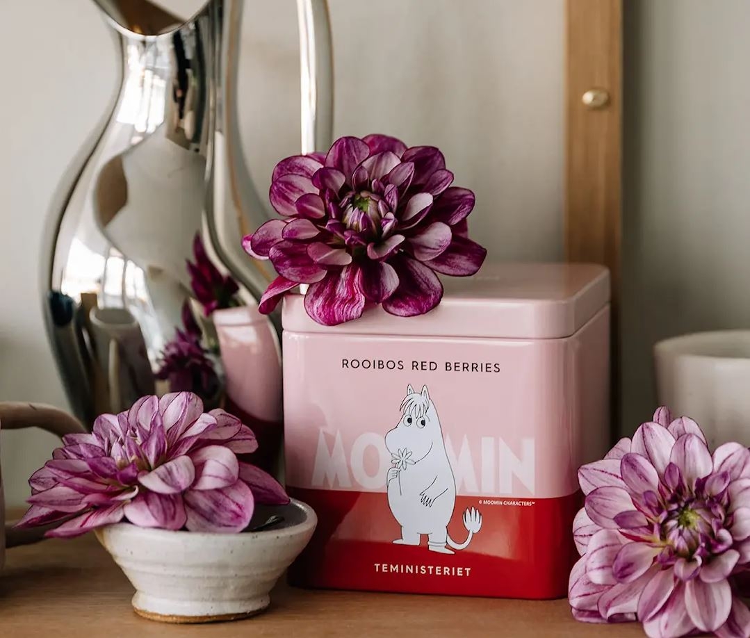 Te i en rosa teburk med mumin på och rosa blommor