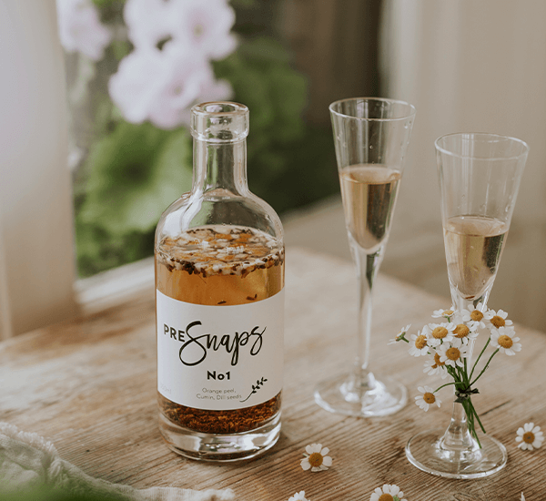 Snapsglass & Shotglass med snaps i på trebord med prestekrager