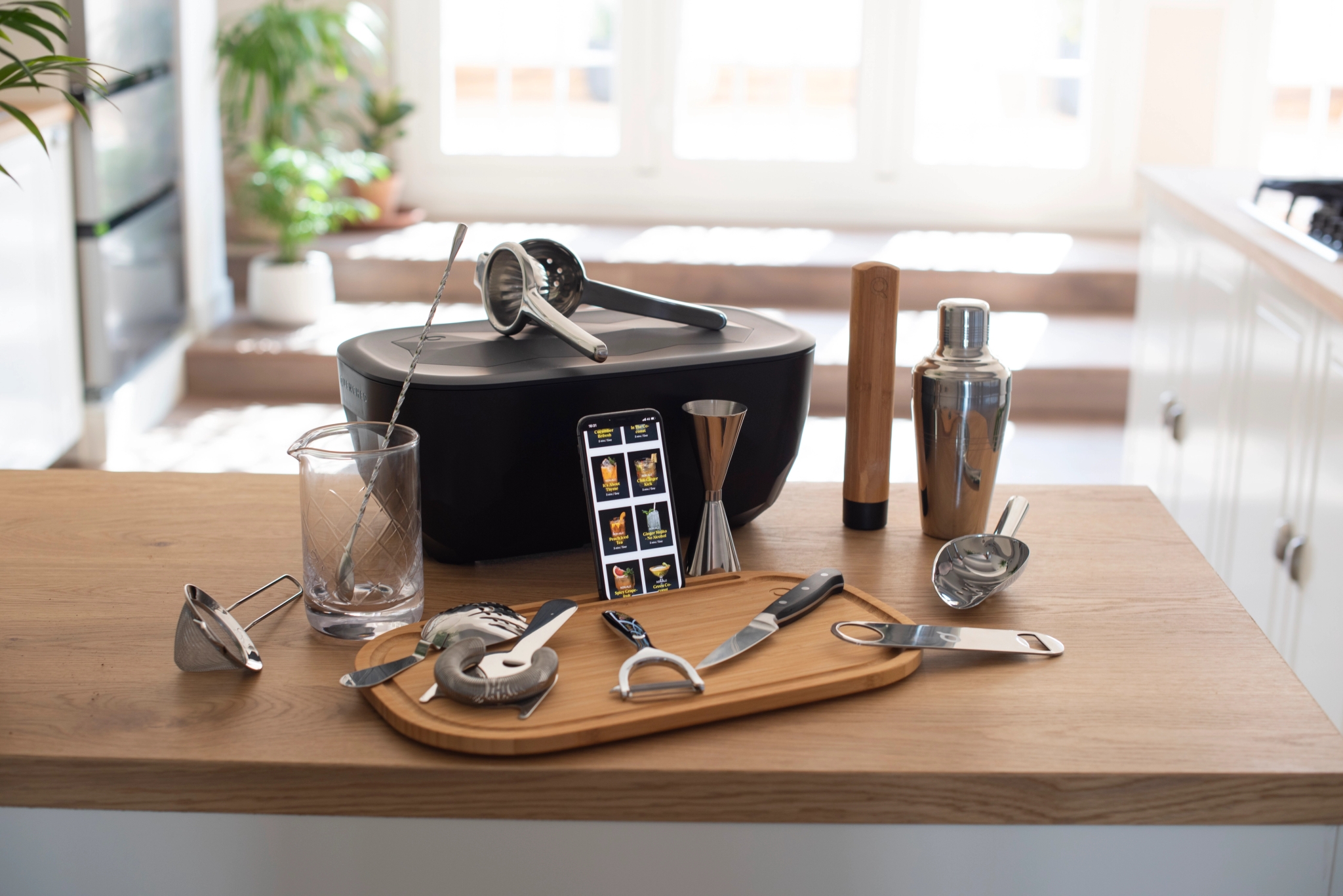 Drinkar är redo att blandas - shaker, mätglas, citruspress, sil och barsked på en köksbänk
