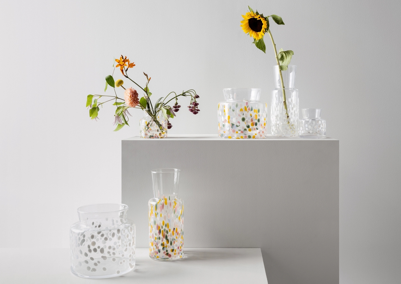Klara glasvaser med färgglada prickar från Kosta Boda med somriga blommor i