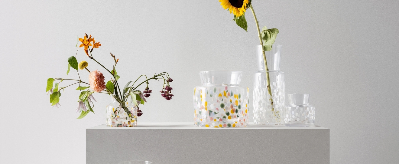 Klara glasvaser med färgglada prickar från Kosta Boda med somriga blommor i
