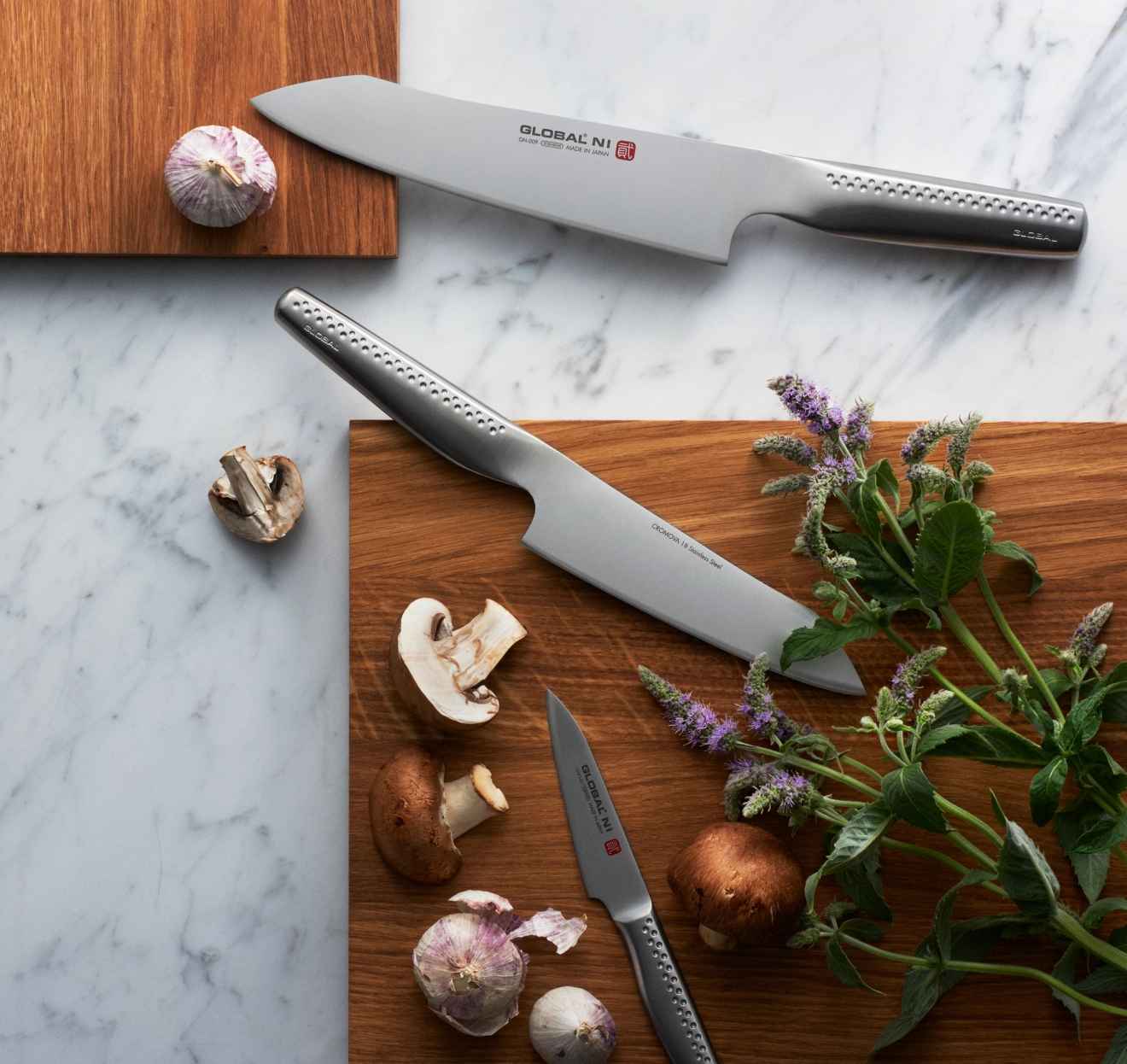Kockknivar ligger på skärbrädor med svamp och vitlök