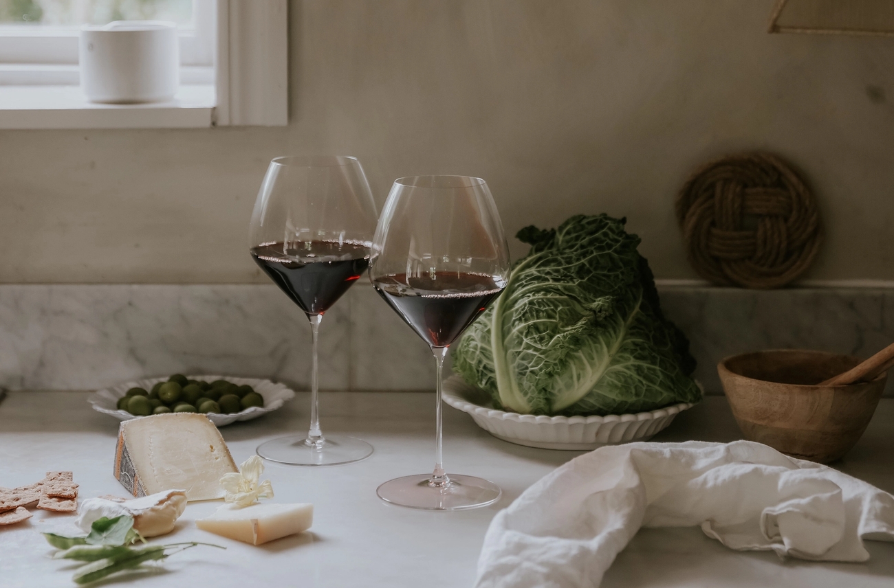 Två glas rödvin står på en köksbänk.