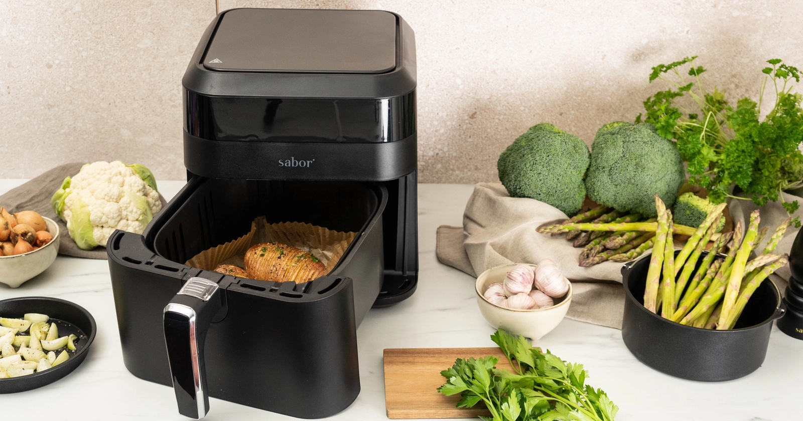Sabor Musta airfryer keittiön työtasolla täynnä ruokaa