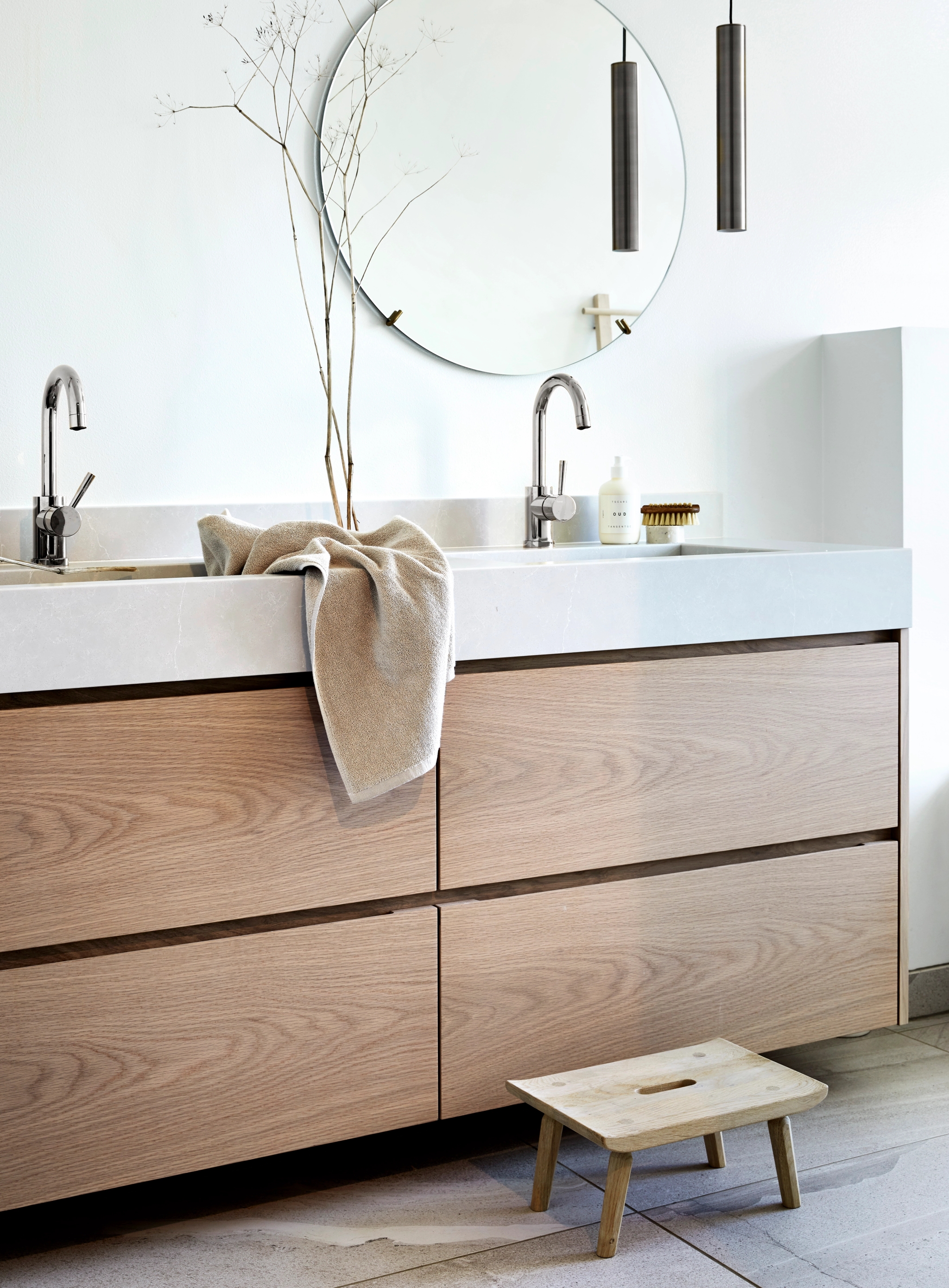 Spegel, handfat och kommod i trä i ett badrum